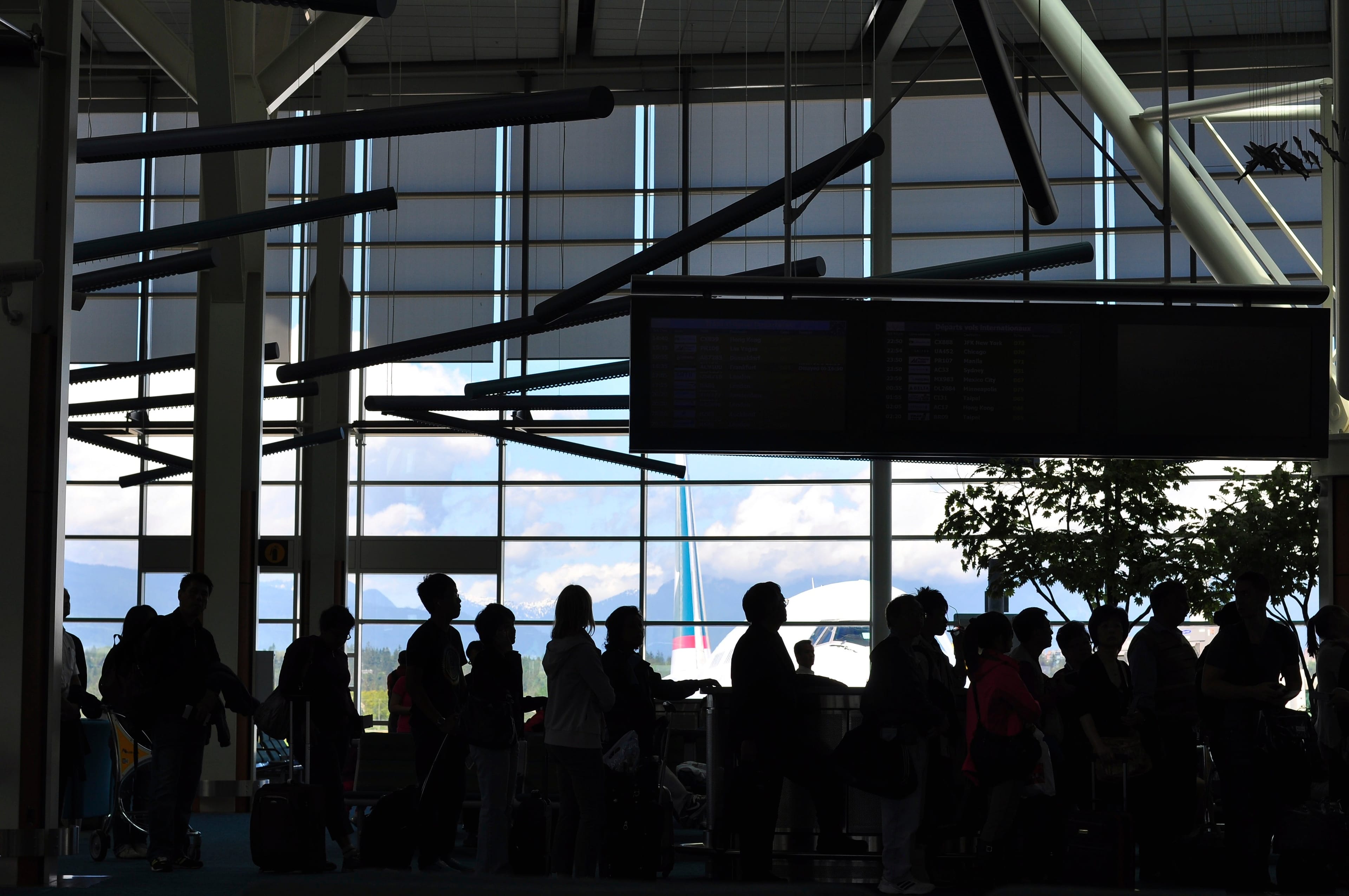 People wait to board a flight at the Vancouver airport. (Getty Images)
