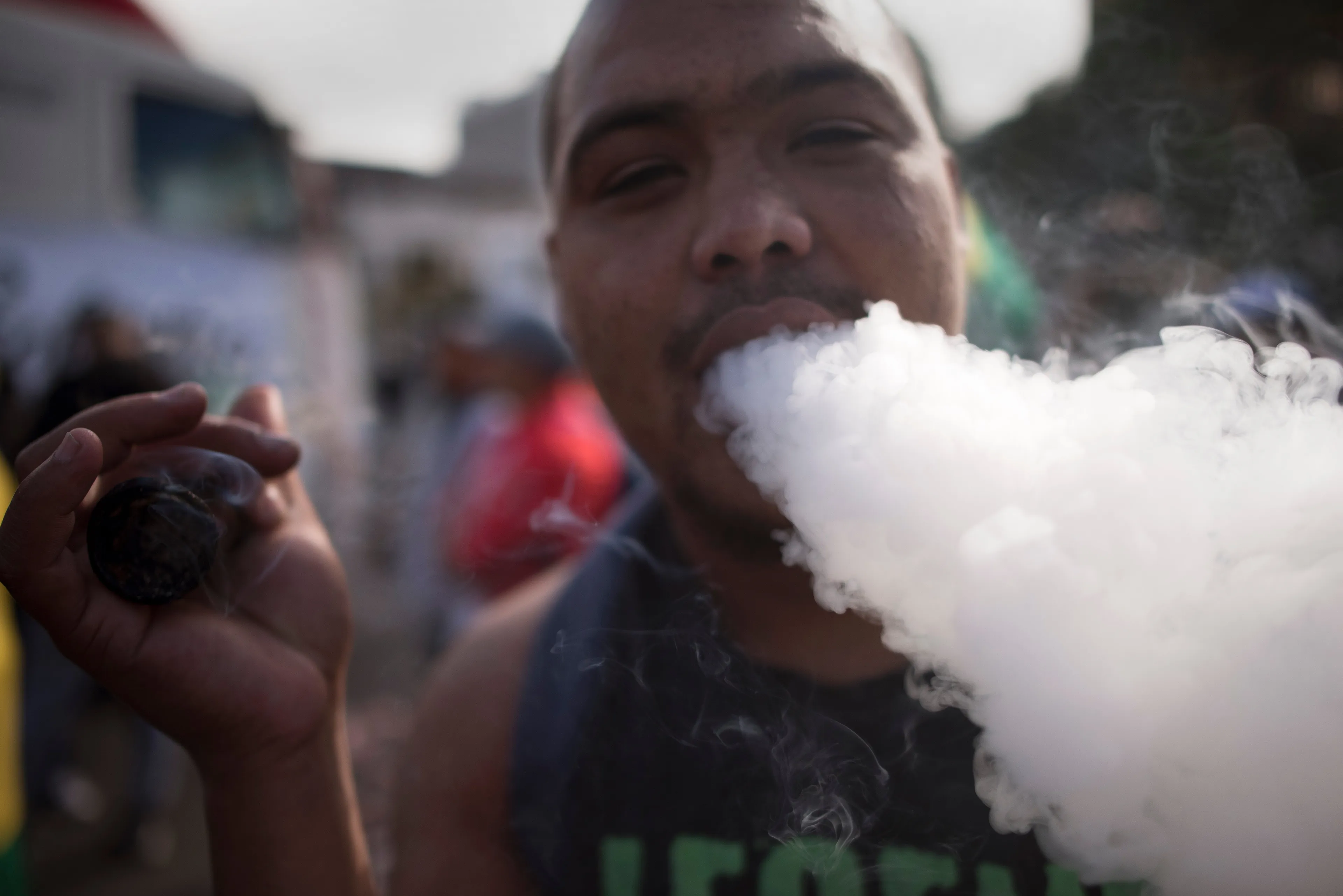 A man exhales smoke as he smokes marijuana out of a bottle-neck pipe. (Photo: RODGER BOSCH/AFP/Getty Images)