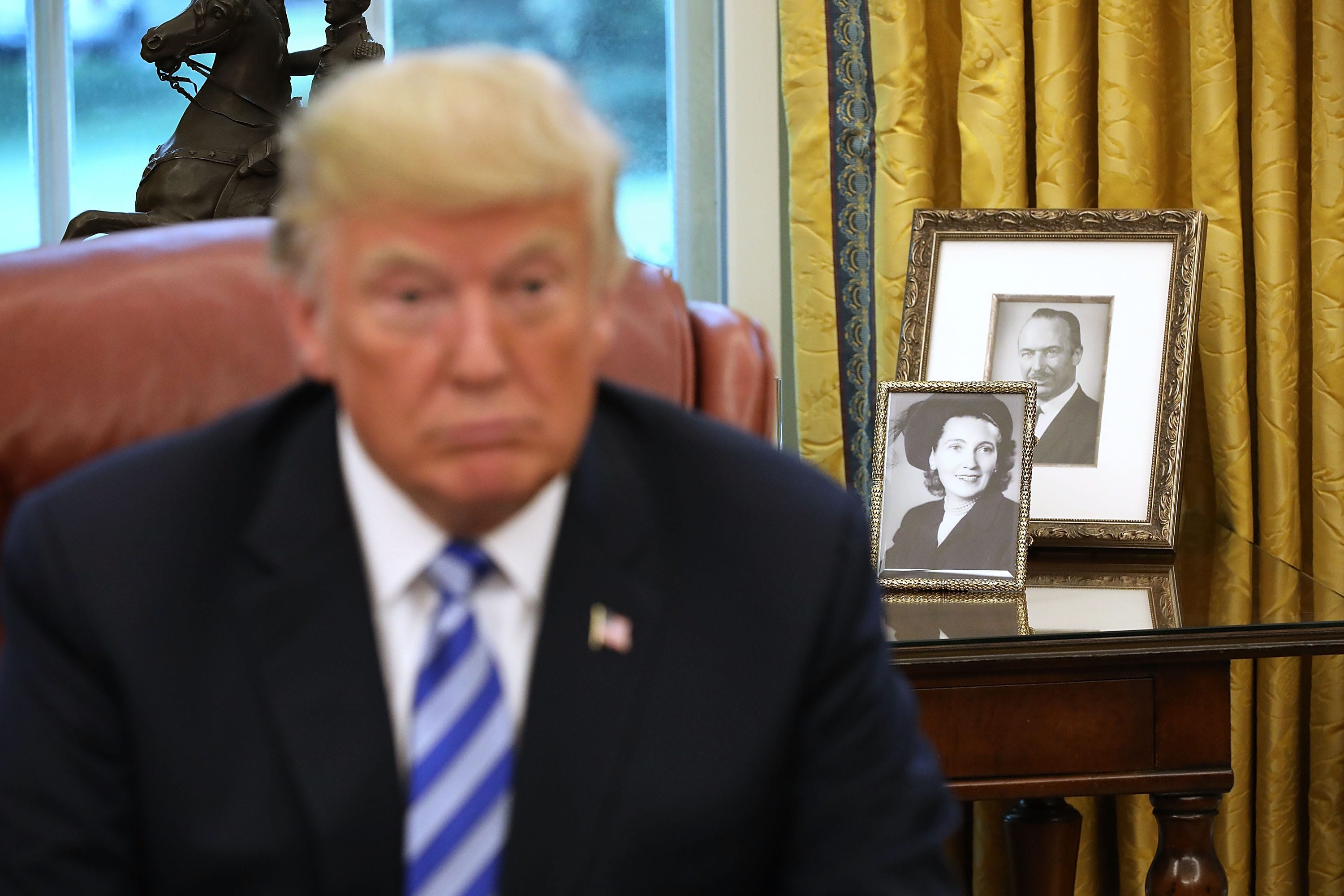 Framed photographs of U.S. President Donald Trump's parents, Fred and Mary Trump, sit on a table in the Oval Office behind the president on Aug. 28, 2018, in Washington, DC.(Chip Somodevilla/Getty Images)