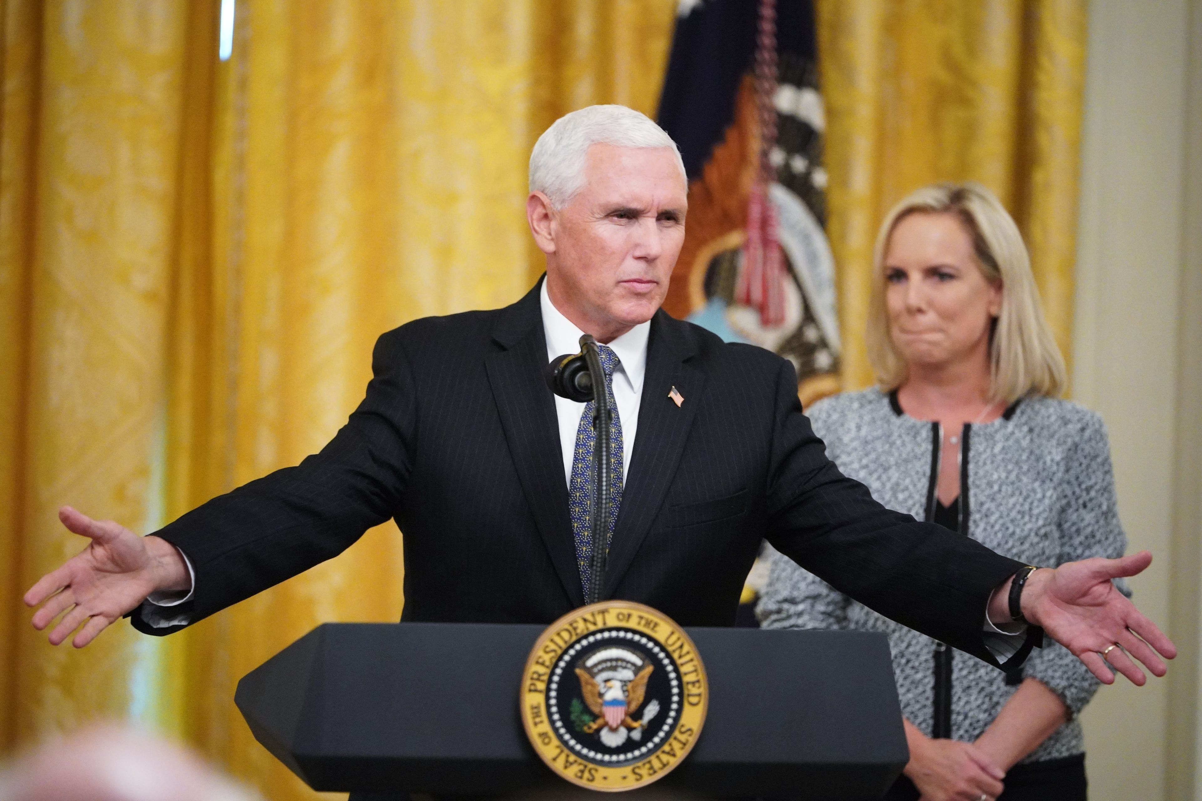 U.S. Vice President Mike Pence (L) speaks during an event honoring the Immigration and Customs Enforcement and Customs and Border Protection services in the East Room of the White House in Washington, DC on August 20, 2018. At right is Homeland Security Secretary Kirstjen Nielsen. (Photo by MANDEL NGAN/AFP/Getty Images)