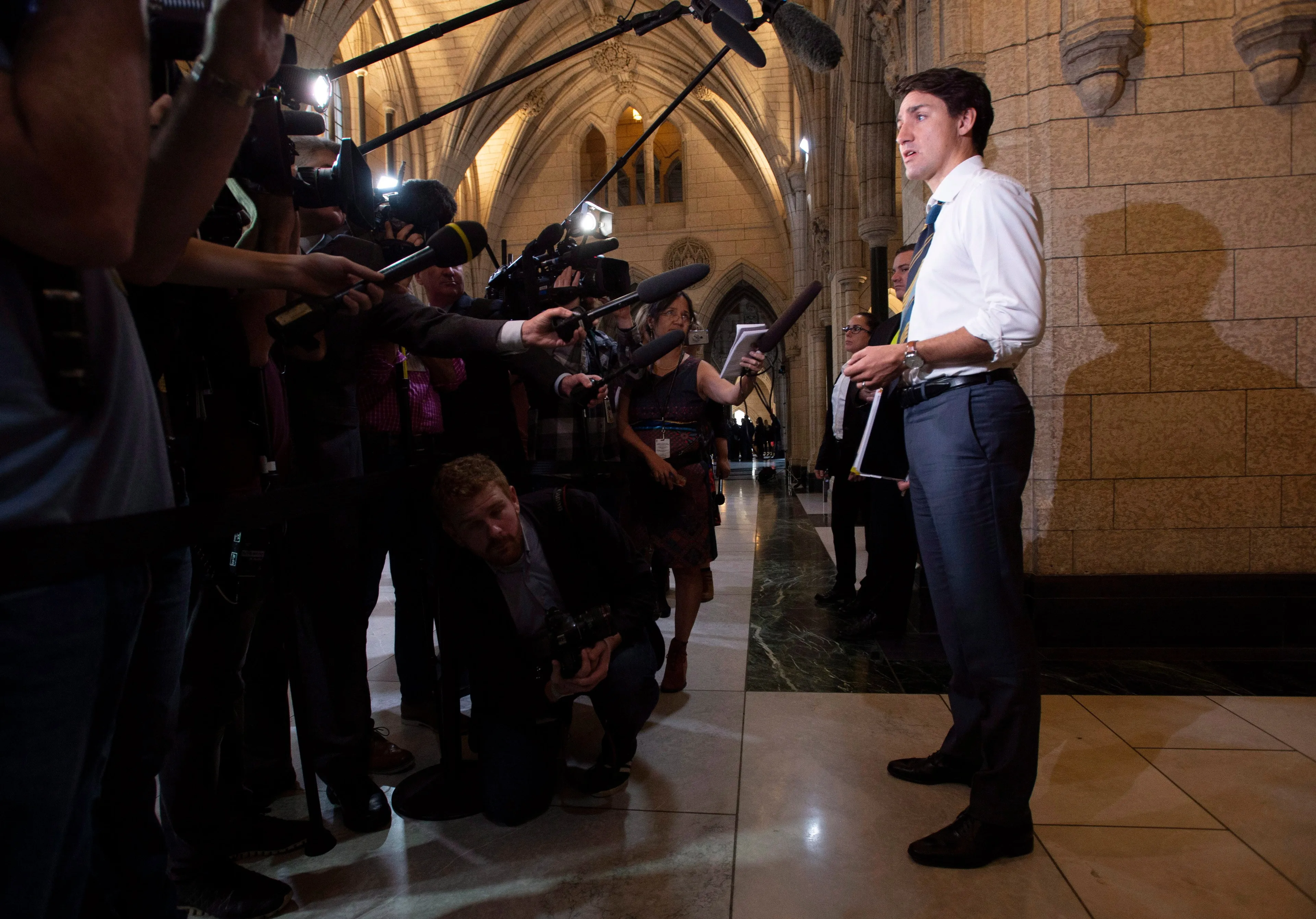 Prime Minister Justin Trudeau s reflected in a sign as he speaks with the media before attending caucus on Parliament Hill in Ottawa, Wednesday Oct. 17, 2018. (THE CANADIAN PRESS/Adrian Wyld)