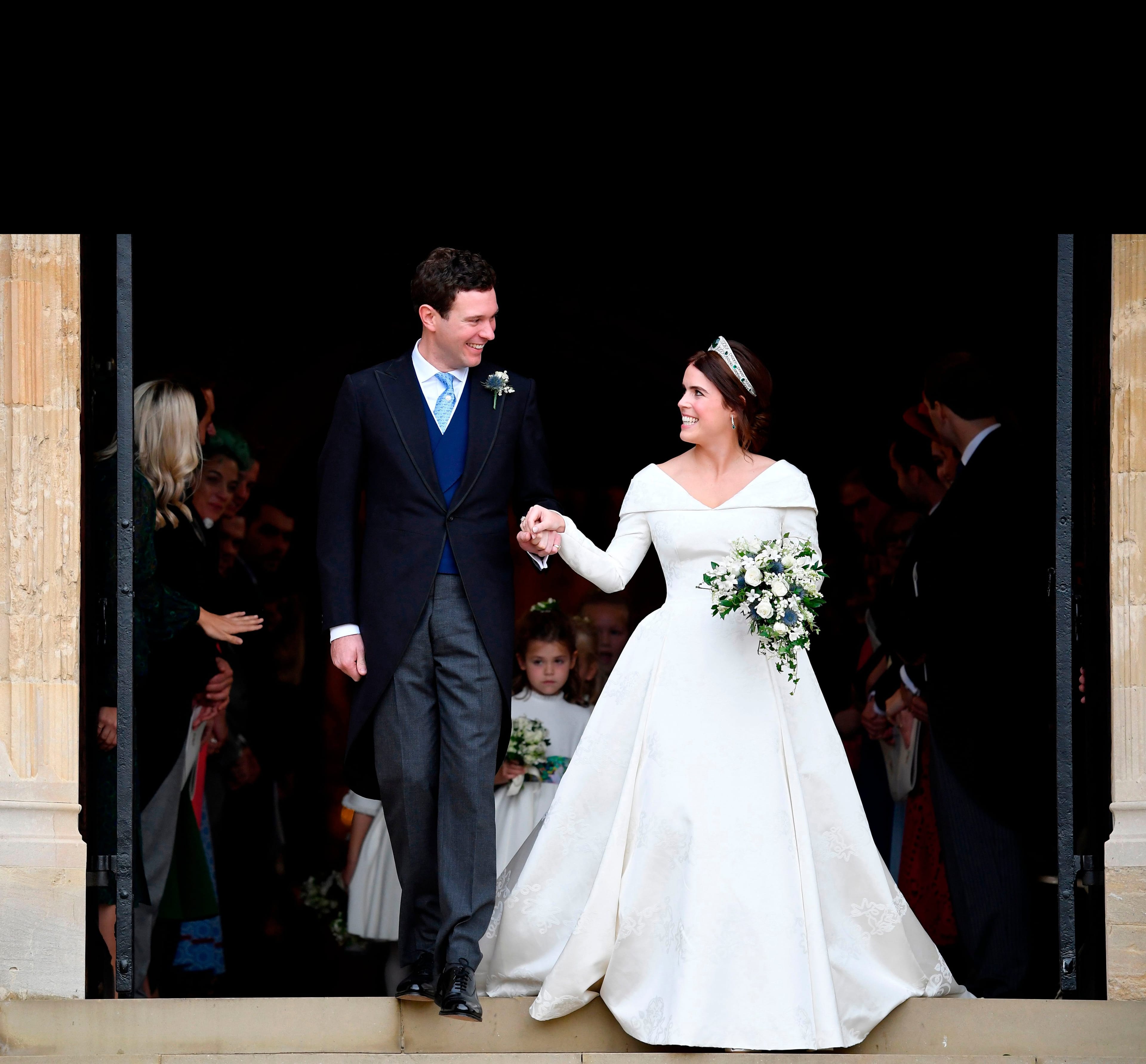 Britain's Princess Eugenie of York (R) and her husband Jack Brooksbank emerge from the West Door of St George's Chapel, Windsor Castle, in Windsor, on October 12, 2018 after their wedding ceremony. (Toby Melville/AFP/Getty Images)