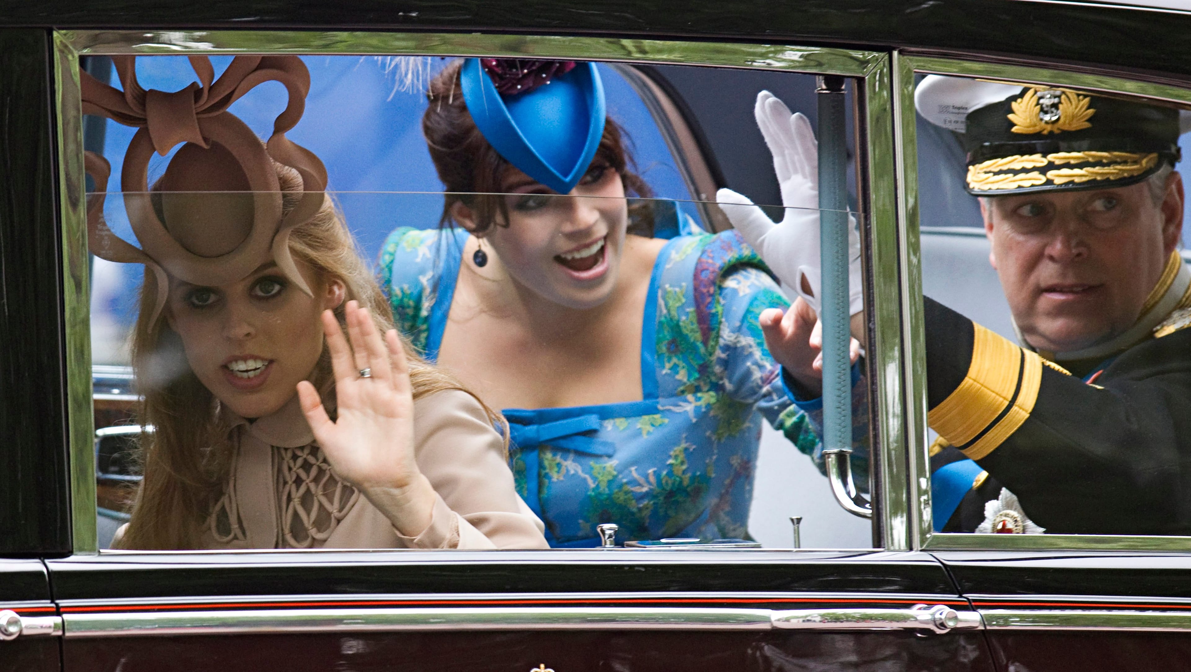 Prince Andrew, Duke of York and his daughters Princess Beatrice (left) and Princess Eugenie (centre) wave as they travel along the processional route to Buckingham Palace after the royal wedding of Prince William, Duke of Cambridge and Catherine, Duchess of Cambridge at Westminster Abbey on April 29, 2011 in London, England. (Warren Allott - WPA Pool/Getty Images)