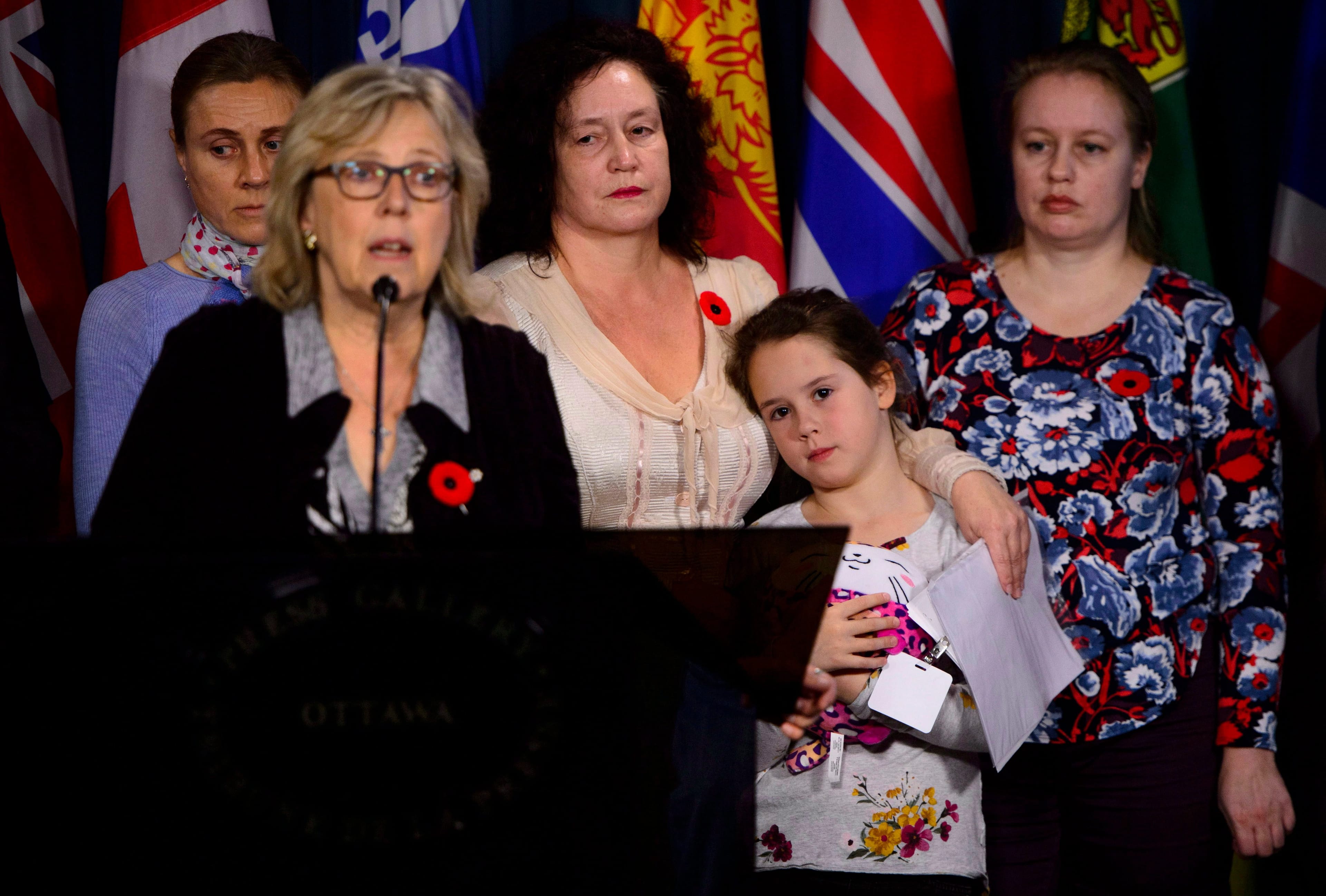 Green Party leader Elizabeth May calls on the federal government to intervene in the case of Elena Musikhina, middle back, who is seen holding her granddaughter Iaroslava (THE CANADIAN PRESS/Sean Kilpatrick)