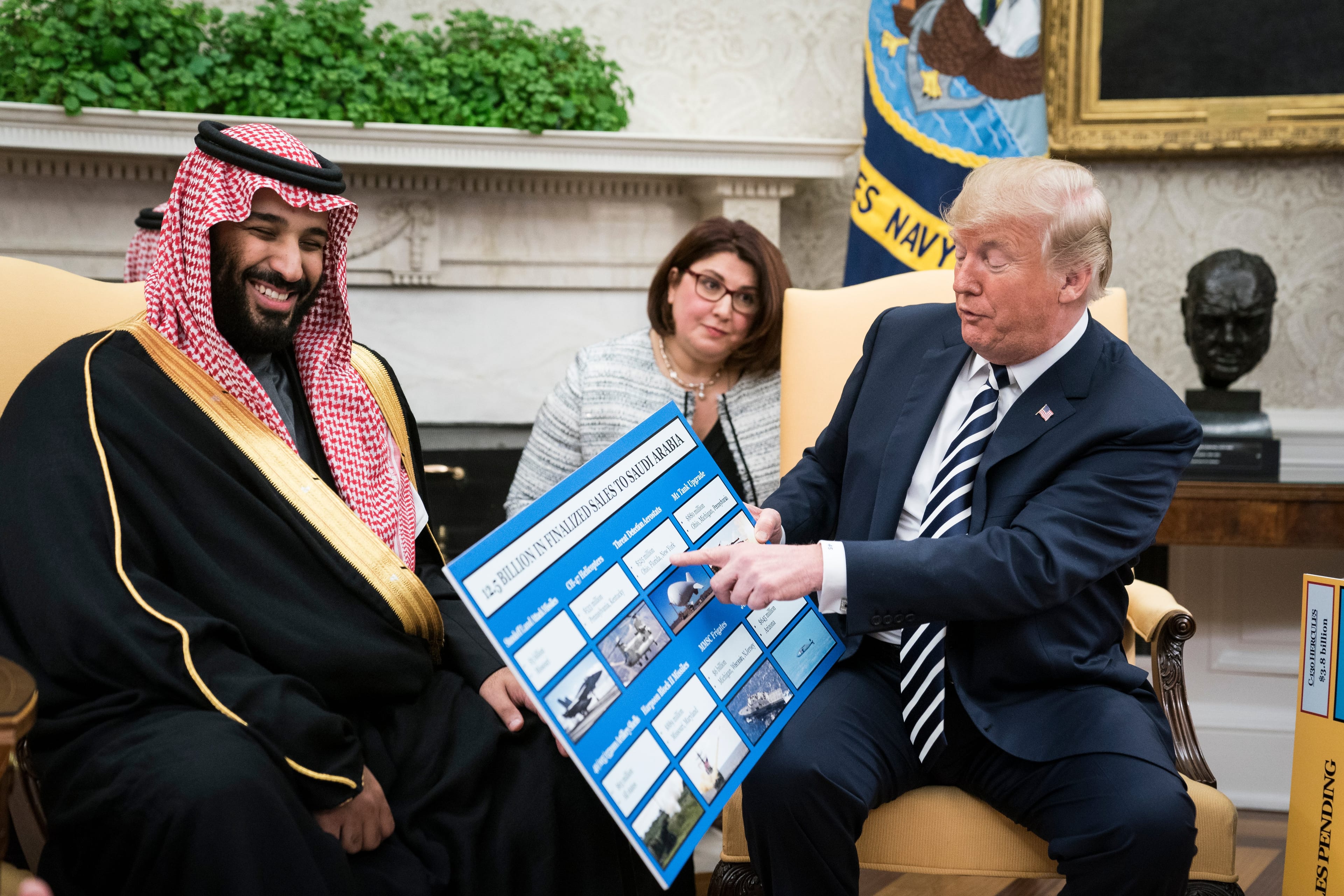 Donald Trump shows off posters as he talks with Crown Prince Mohammed bin Salman in the Oval Office at the White House on Tuesday, March 20, 2018 (Jabin Botsford/The Washington Post via Getty Images)