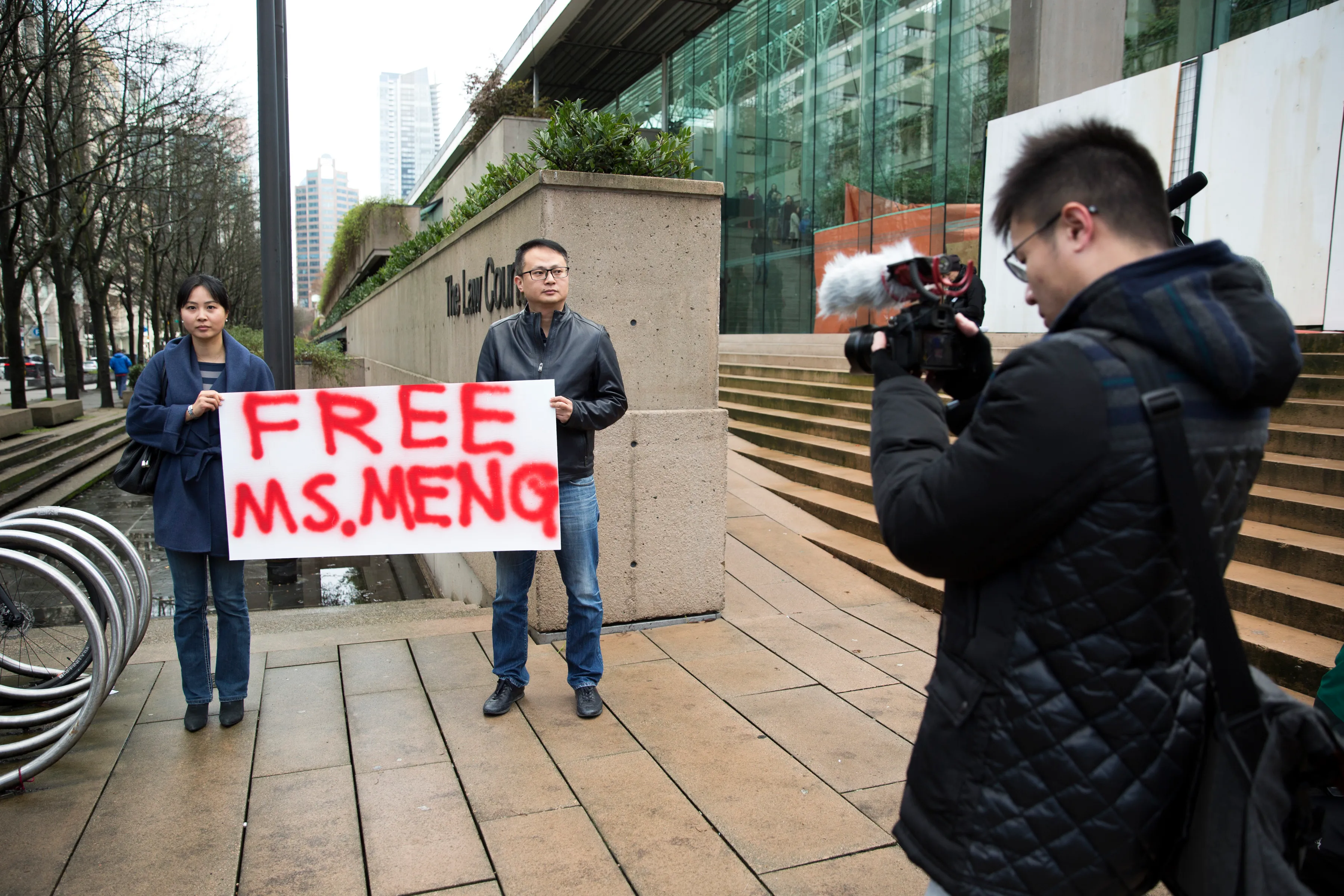 Ada Yu of Vancouver (left) and a man who wished to remain unidentified hold a sign in favour of the release of Huawei Technologies Chief Financial Officer Meng Wanzhou outside her bail hearing in Vancouver on Dec. 10, 2018. (JASON REDMOND/AFP/Getty Images)