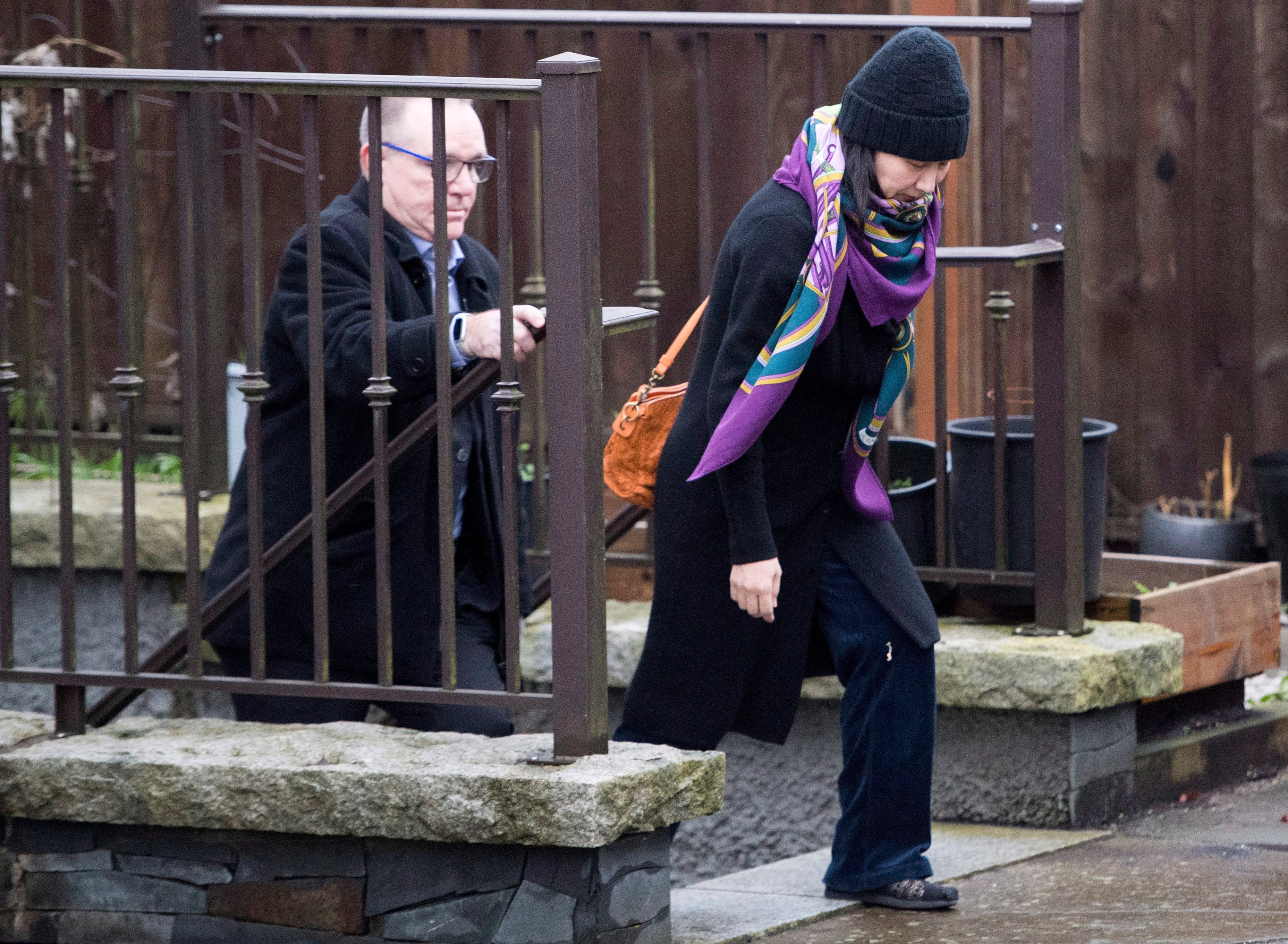 Huawei chief financial officer Meng Wanzhou, leaves her home with a security guard in Vancouver on Wednesday, December 12, 2018. THE CANADIAN PRESS/Jonathan Hayward