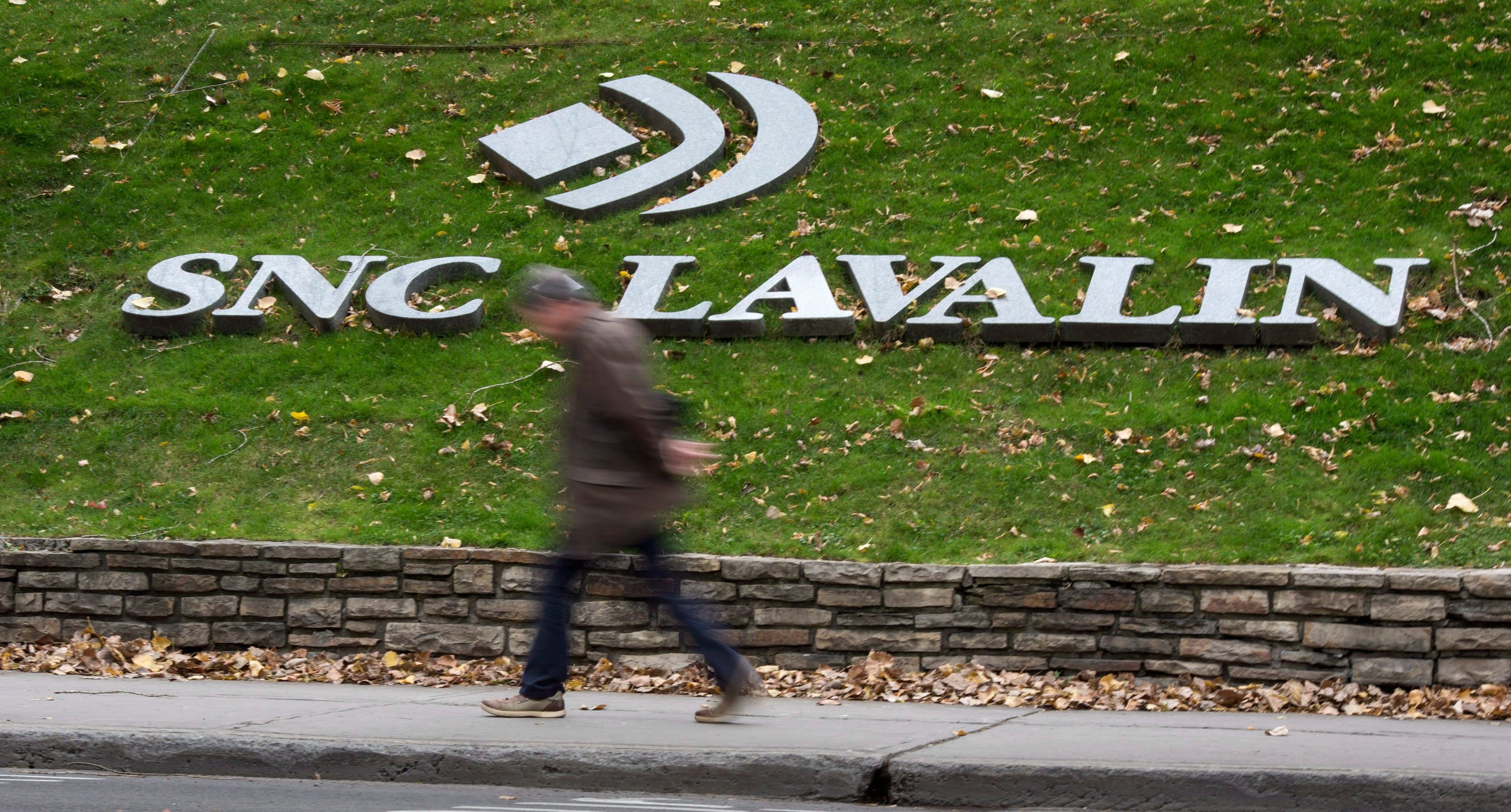 A man walks past the headquarters of SNC Lavalin in Montreal on Nov. 6, 2014. (Paul Chiasson/CP)
