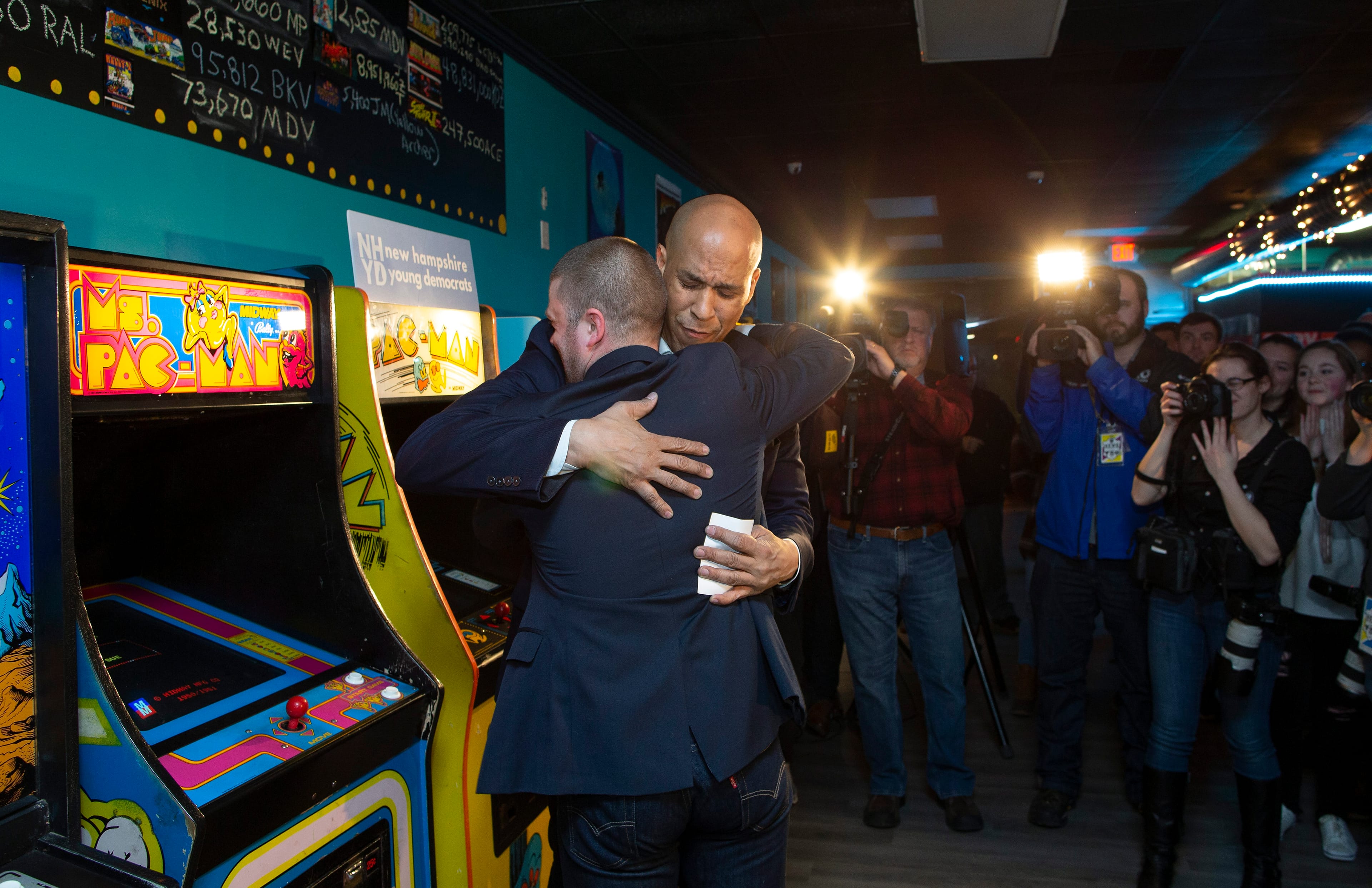 Senator Cory Booker embraces a member of the New Hampshire Young Democrats during a campaign stop at the Electric Avenue Arcade in Manchester, N.H. (EPA/CJ GUNTHER)