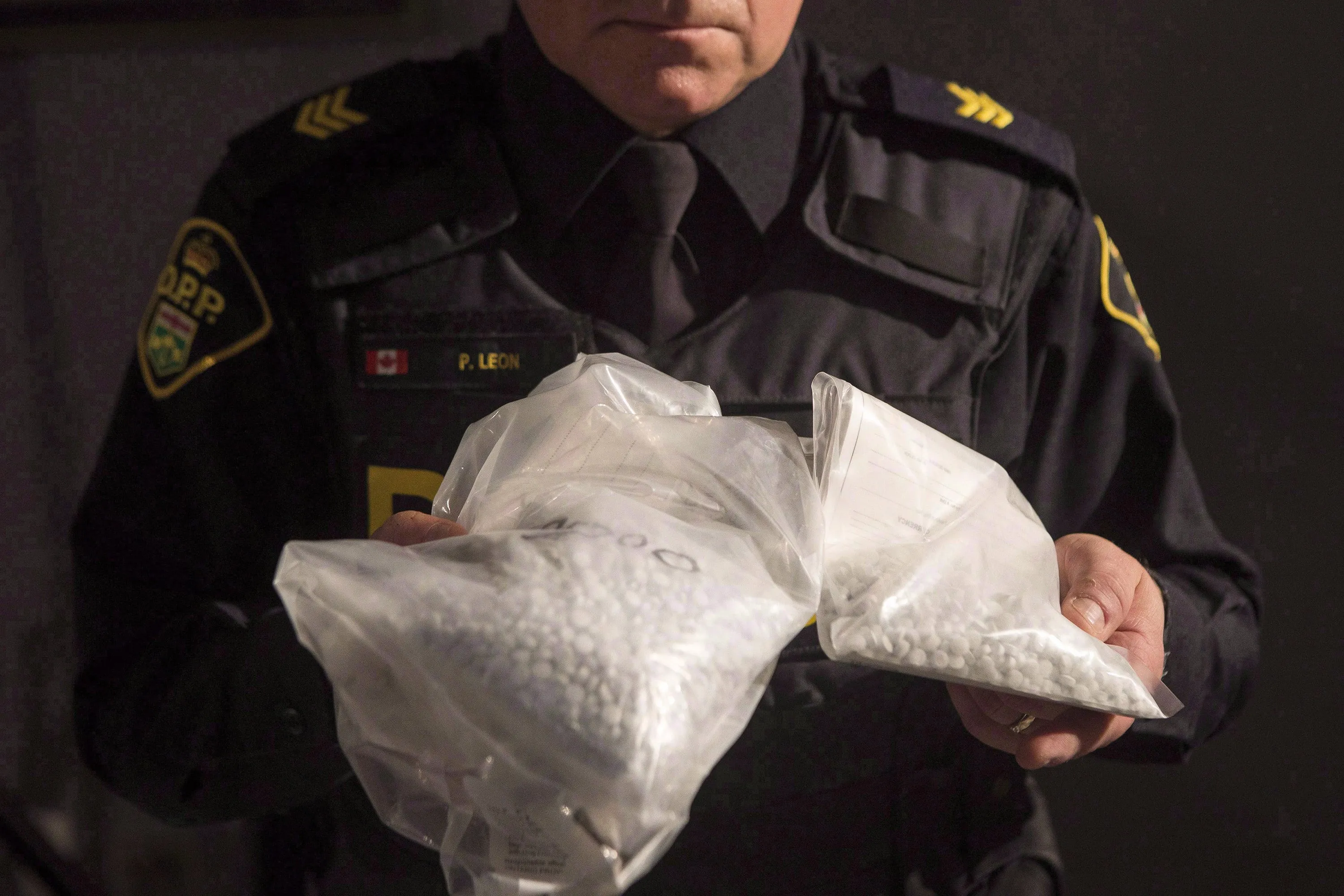 An OPP officer displays bags containing fentanyl (Chris Young/CP)