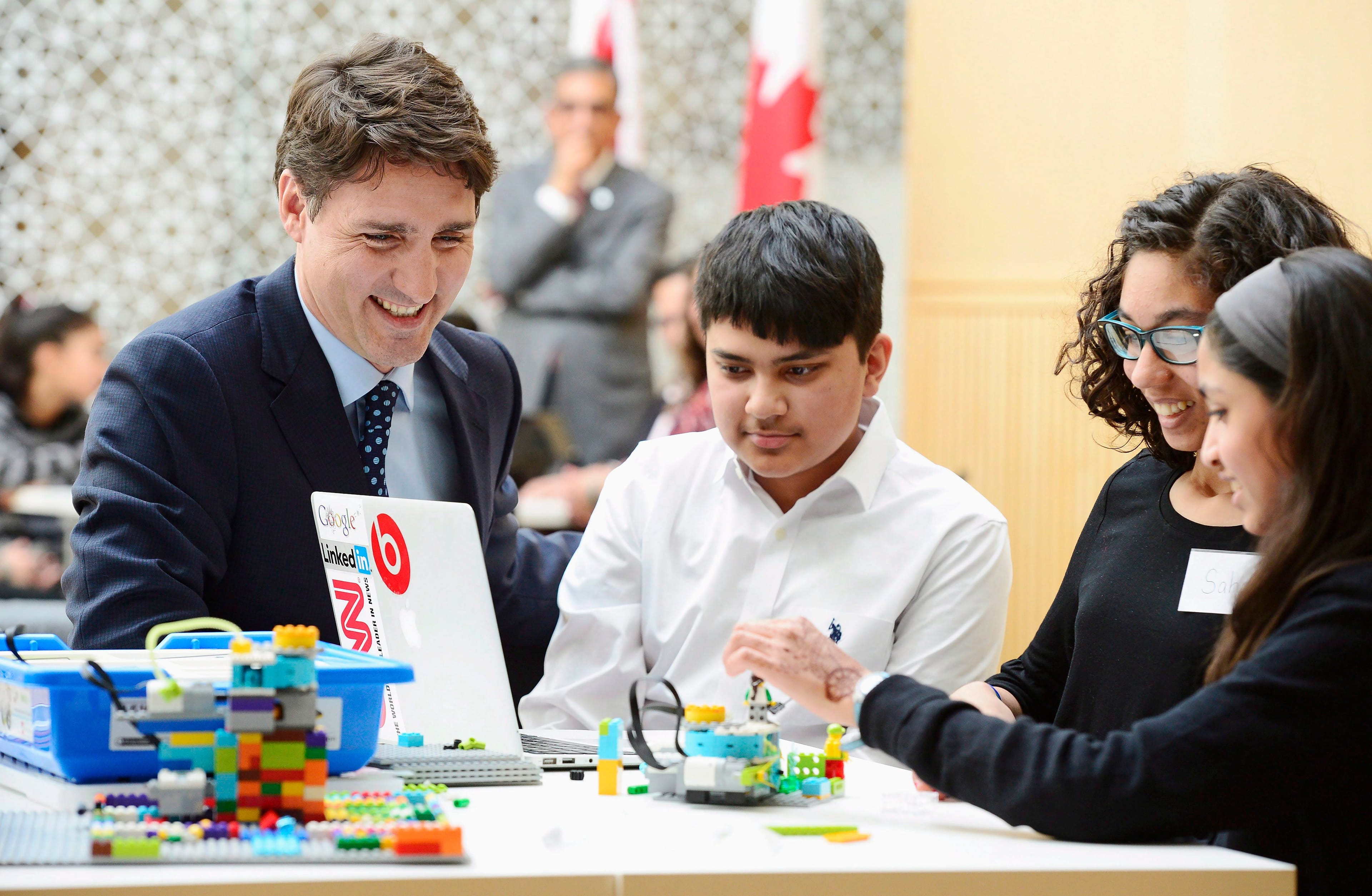 Prime Minister Justin Trudeau watches children working on small robotics in Toronto on Wednesday, March 21, 2018. (Frank Gunn/CP)