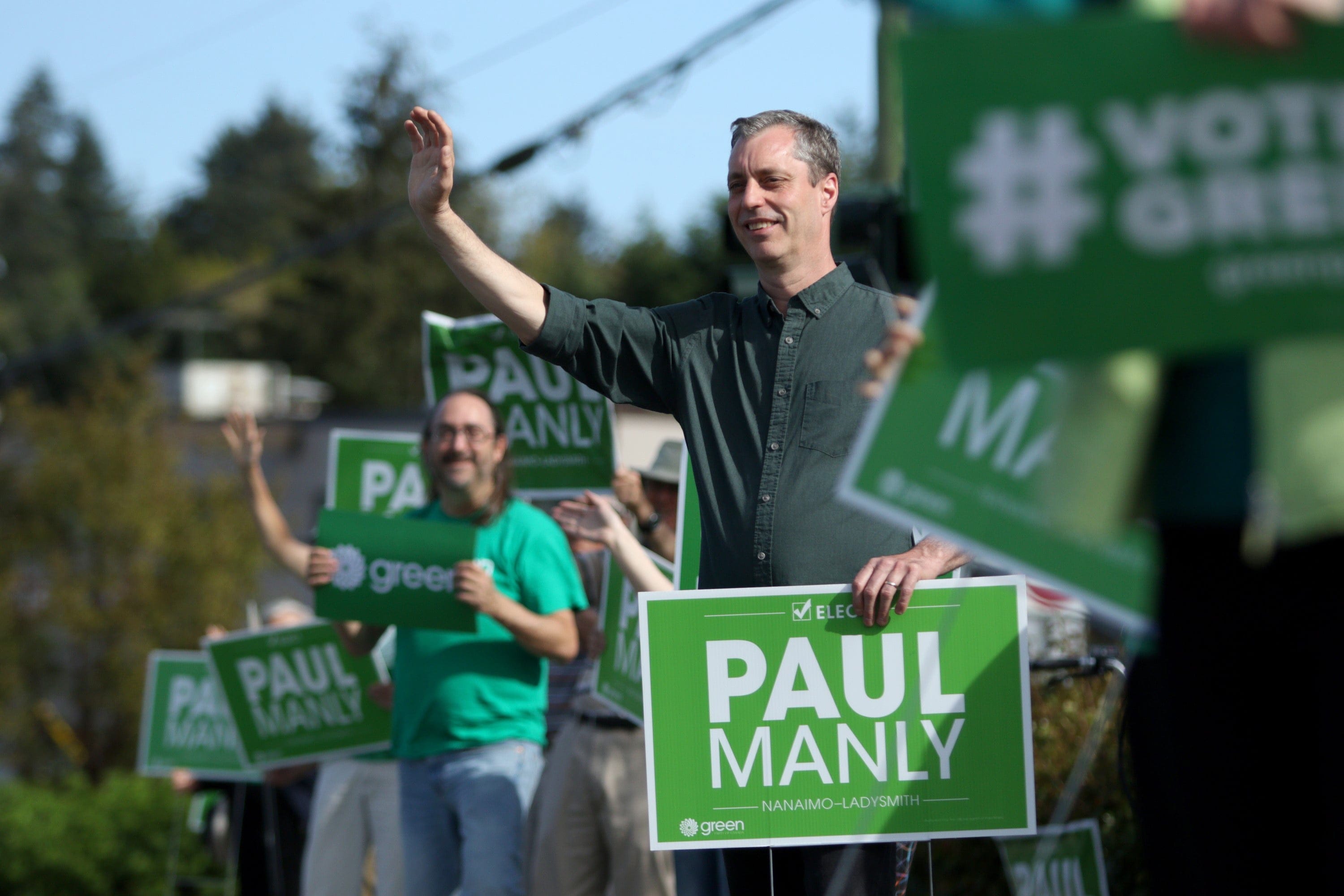 Green party candidate Paul Manly works right up to the end as he takes part in sign waving with supporters near his campaign office before the polls close in the Nanaimo-Ladysmith byelection in Nanaimo, B.C., on Monday, May 6, 2019. (Chad Hipolito/CP)
