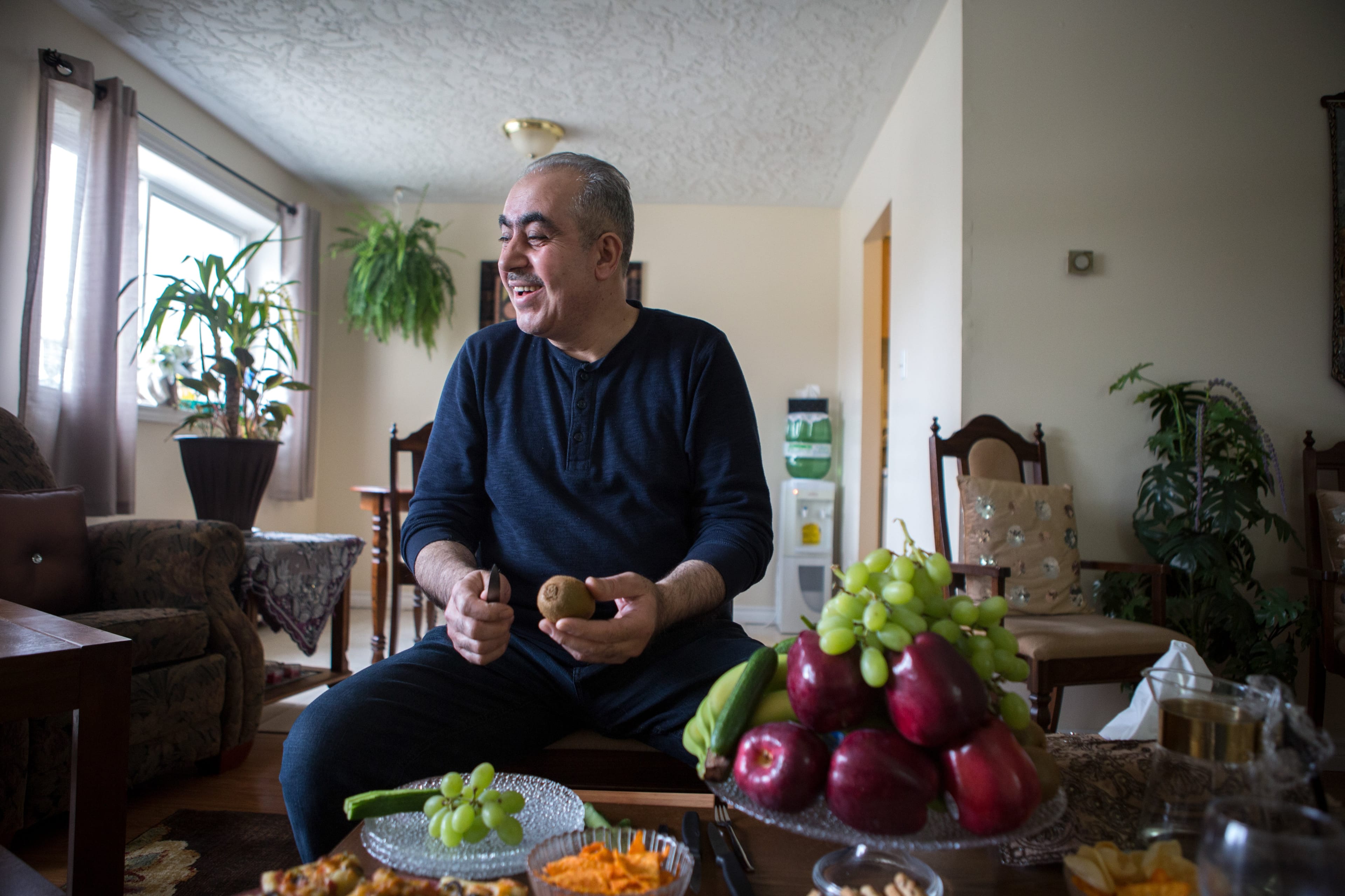 Badr prepares a plate of fruit at his family’s apartment in Kitchener (Photograph by Chris Donovan)