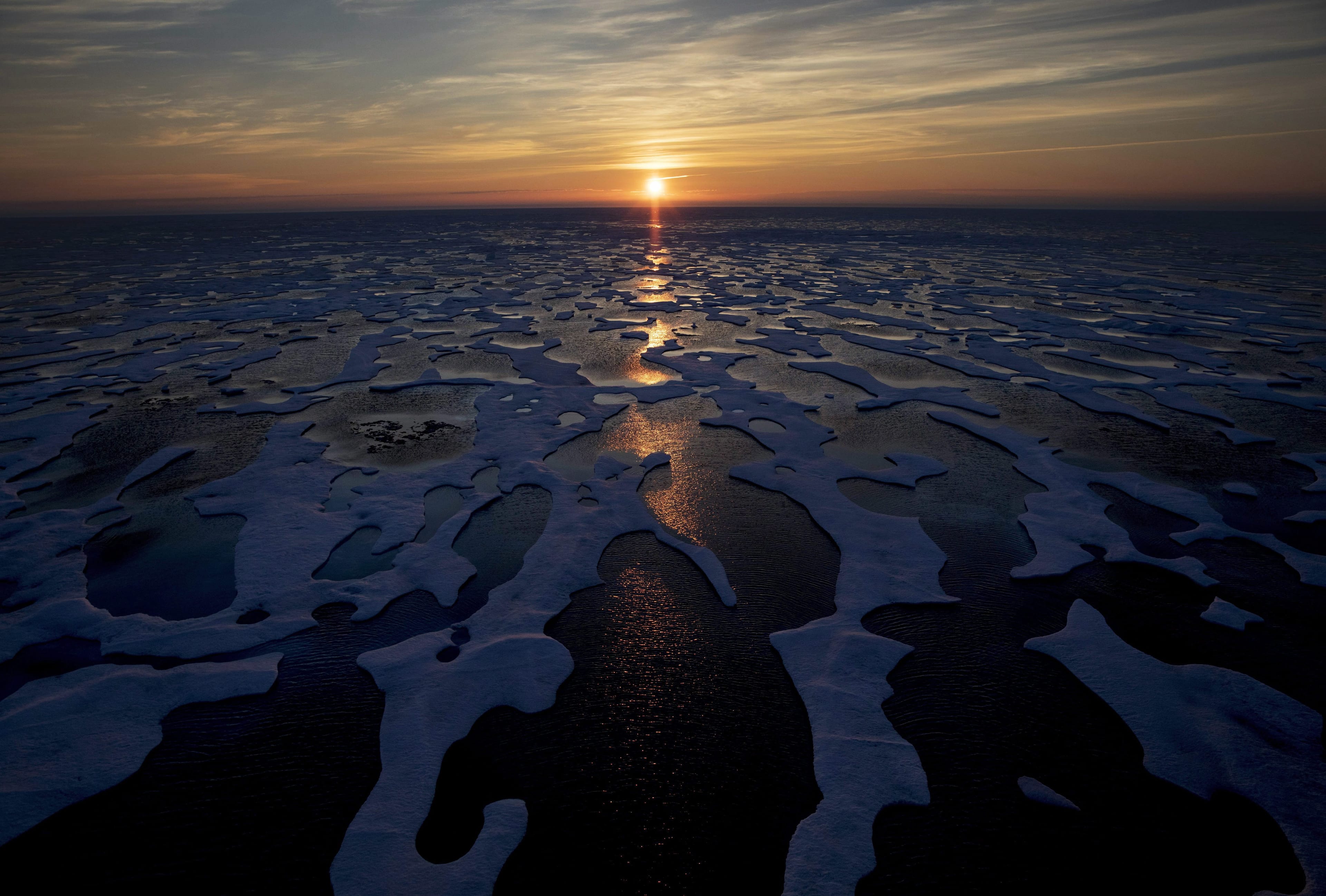 The midnight sun shines across sea ice along the Northwest Passage in the Canadian Arctic Archipelago, on July 22, 2017. Canada is warming up twice as fast as the rest of the world and that warming is "effectively irreversible" a new scientific report from Environment and Climate Change Canada says. (David Goldman/AP/CP)