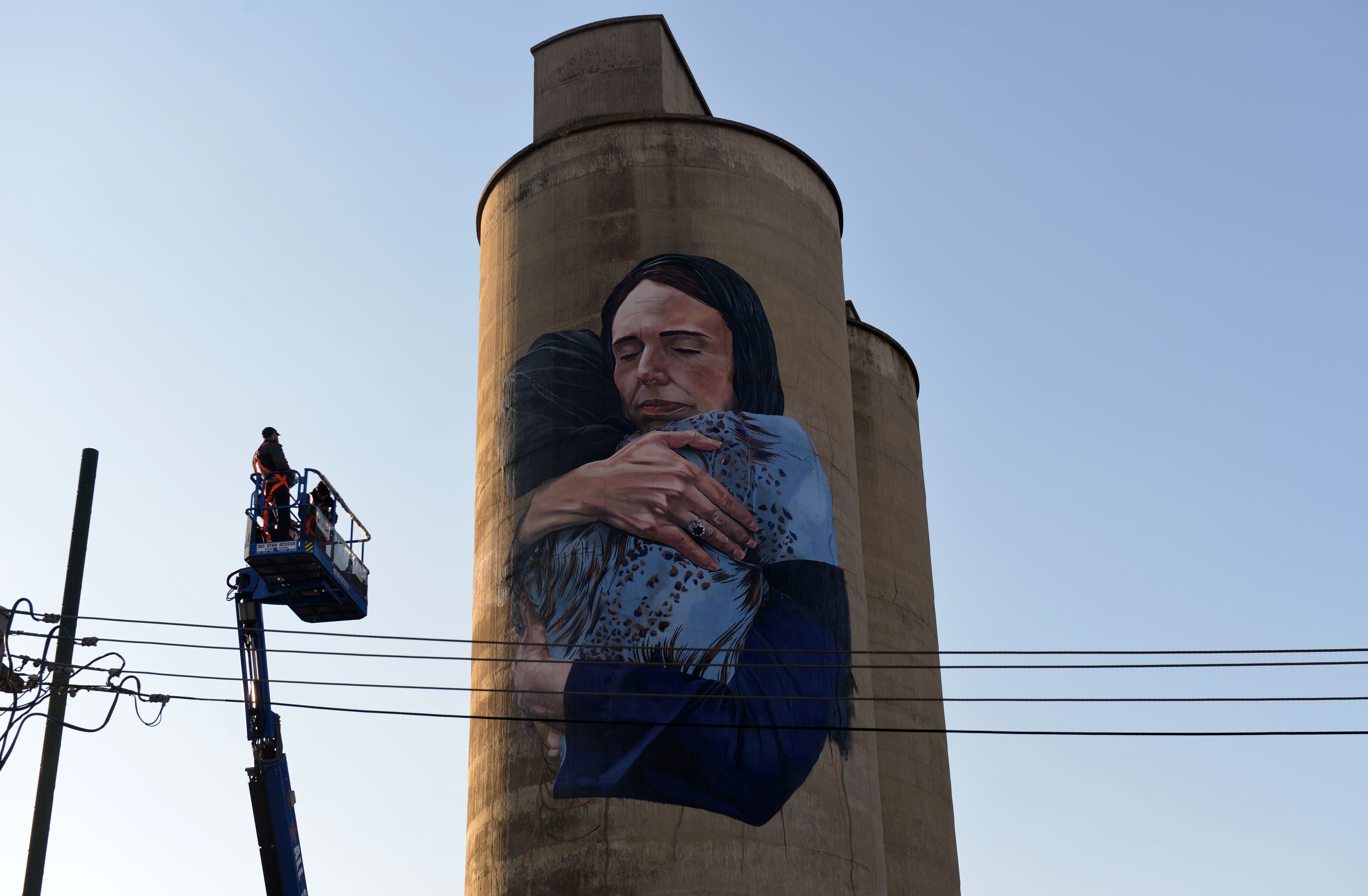 A photograph of the NZ PM embracing a Muslim woman reproduced by artist Loretta Lizzio as an 18-metre mural on a silo in Melbourne (Recep Sakar/Anadolu Agency/Getty Images)