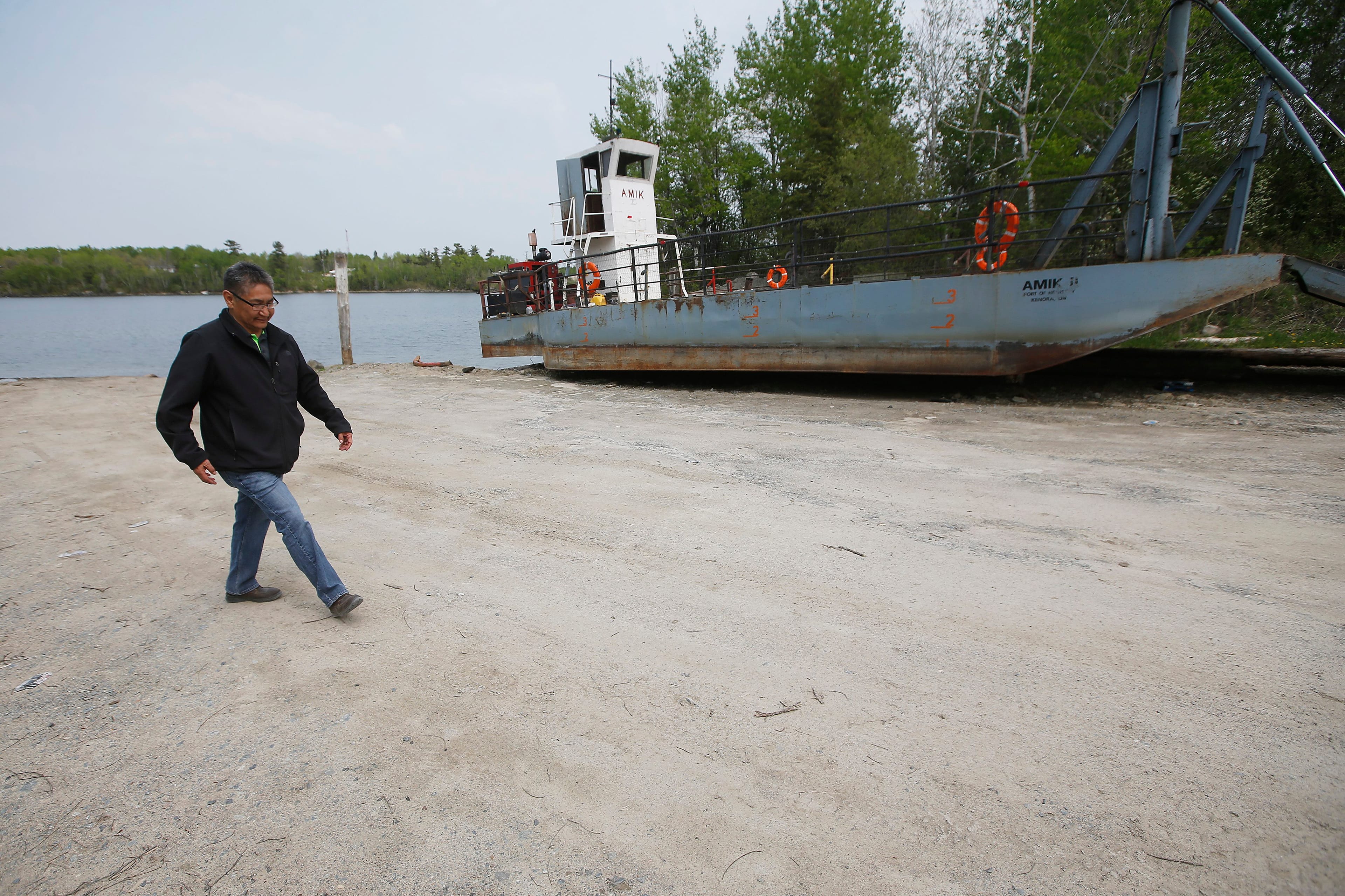 Chief Erwin Redsky of Shoal Lake 40 First Nation walks past the old ferry the community used to get to the mainland, May 30, 2019 (John Woods/CP)