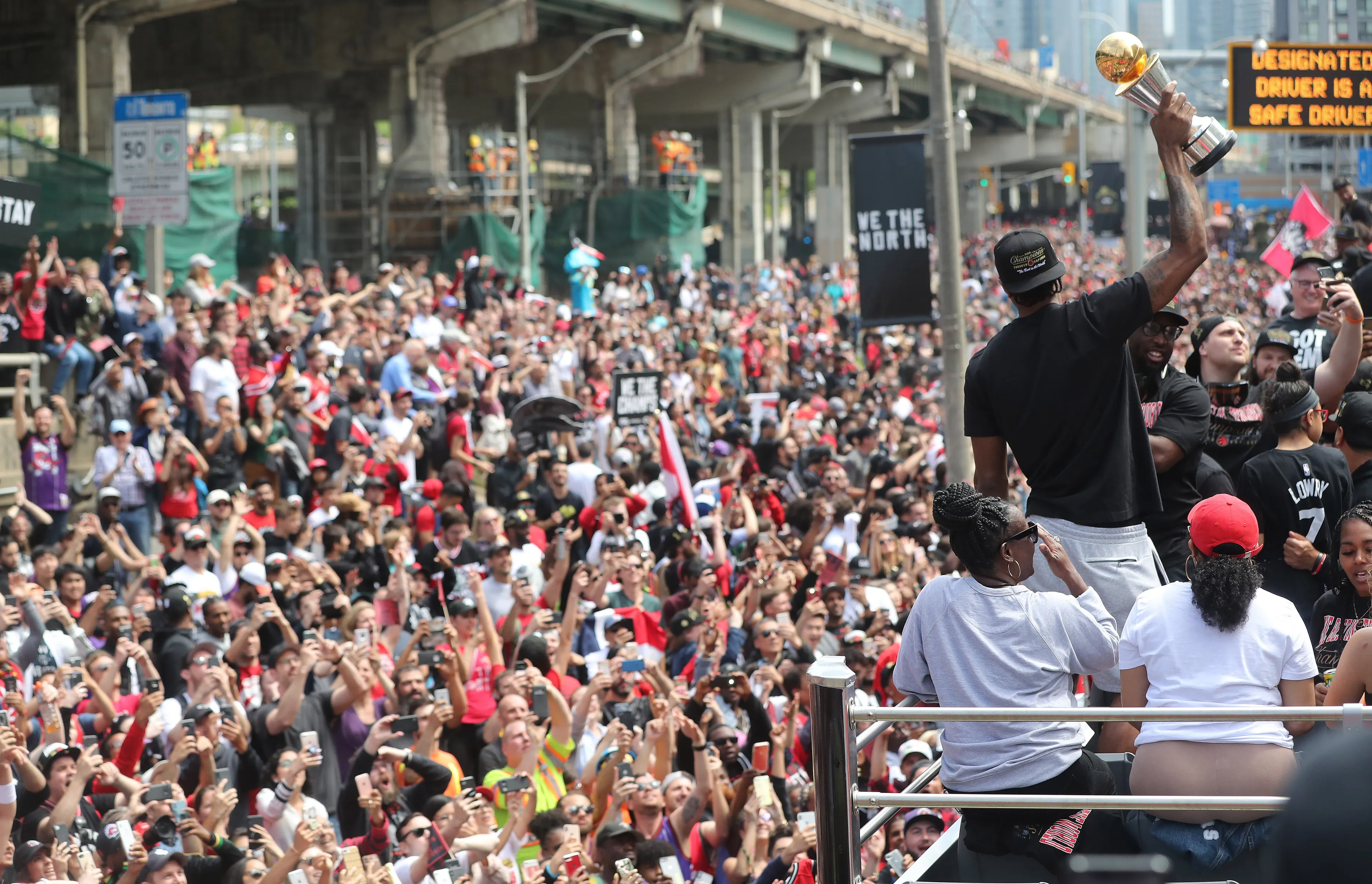 Kawhi Leonard holds up his MVP Trophy to fans lining the route as the Toronto Raptors hold their victory parade after beating the Golden State Warriors in the NBA Finals in Toronto. June 17, 2019. (Steve Russell/Toronto Star via Getty Images)