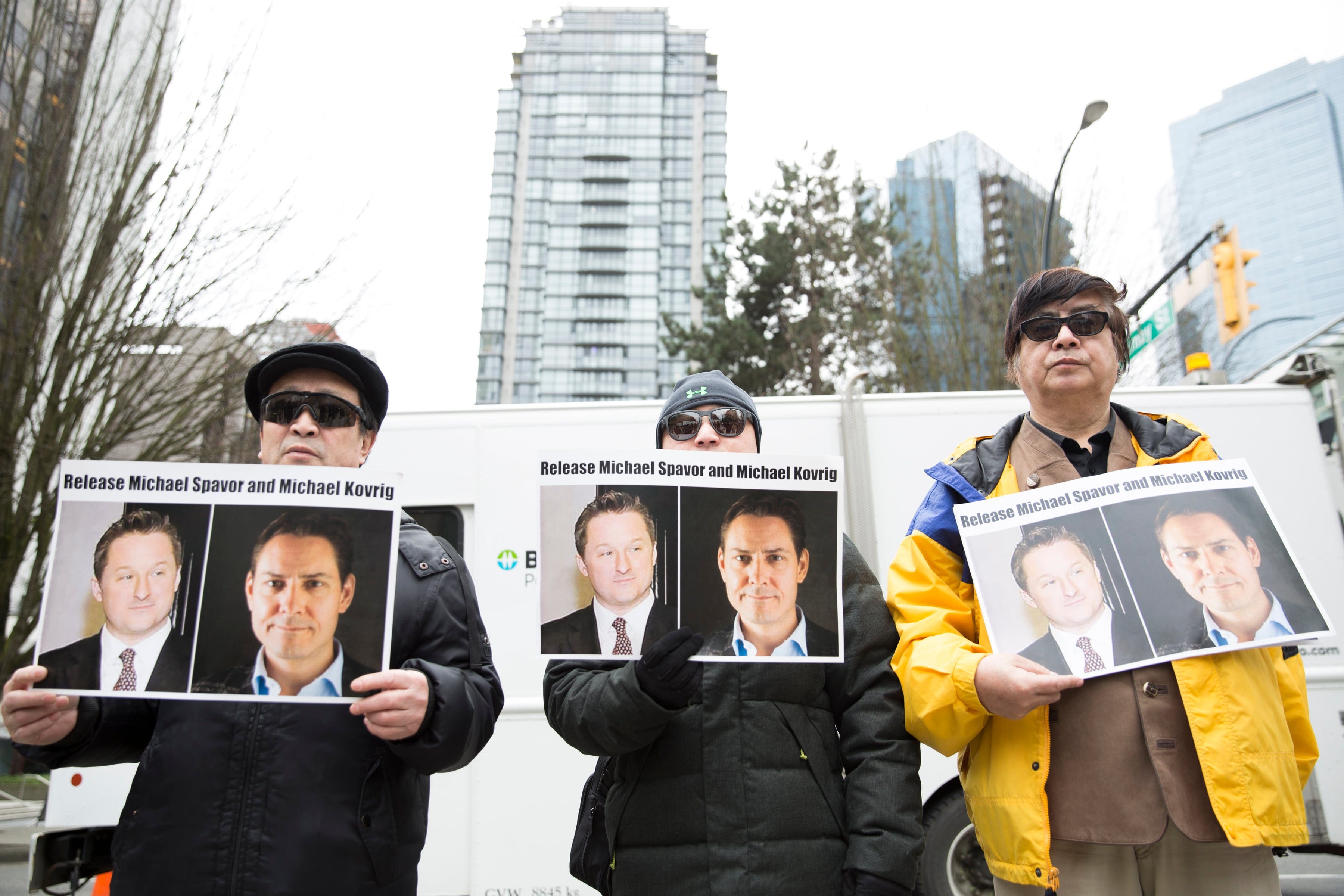 Protesters hold photos of Canadians Michael Spavor and Michael Kovrig, who are being detained by China, outside British Columbia Supreme Court, in Vancouver, on Mar. 6, 2019. (JASON REDMOND/AFP/Getty Images)