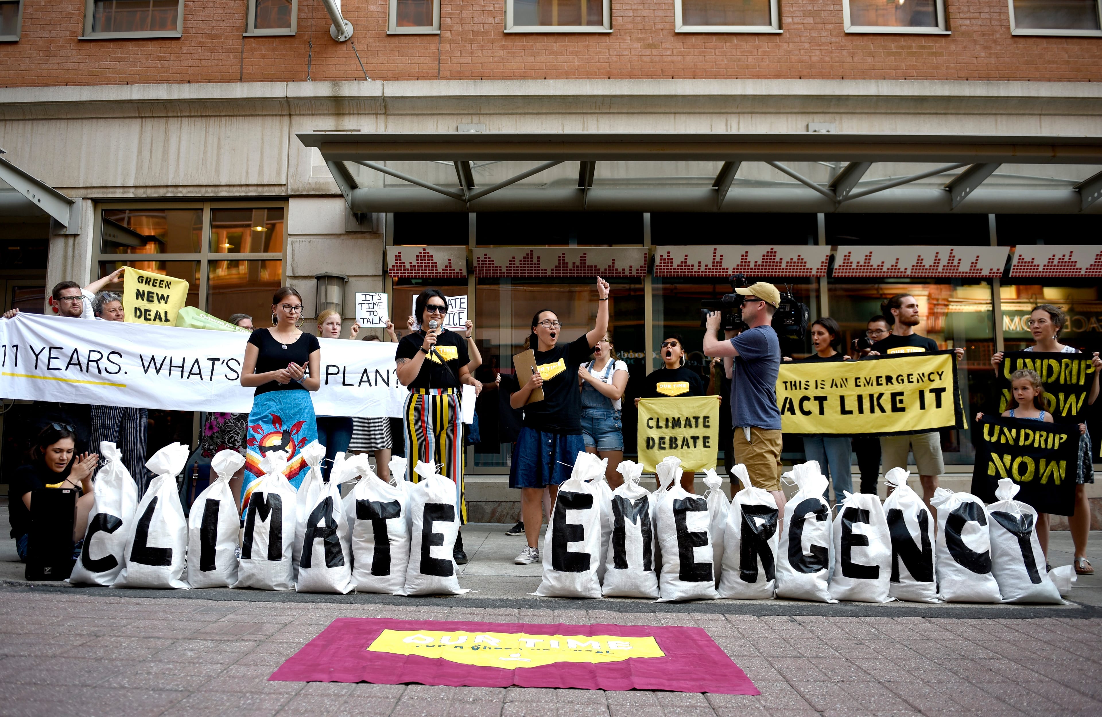 Sandbags symbolizing the link between climate change and local flooding are placed outside the CBC Ottawa newsroom during a rally calling for the public broadcaster to host a federal leader's debate on climate change and a Green New Deal for Canada for the 2019 election, on Wednesday, July 17, 2019. (CP/Justin Tang)