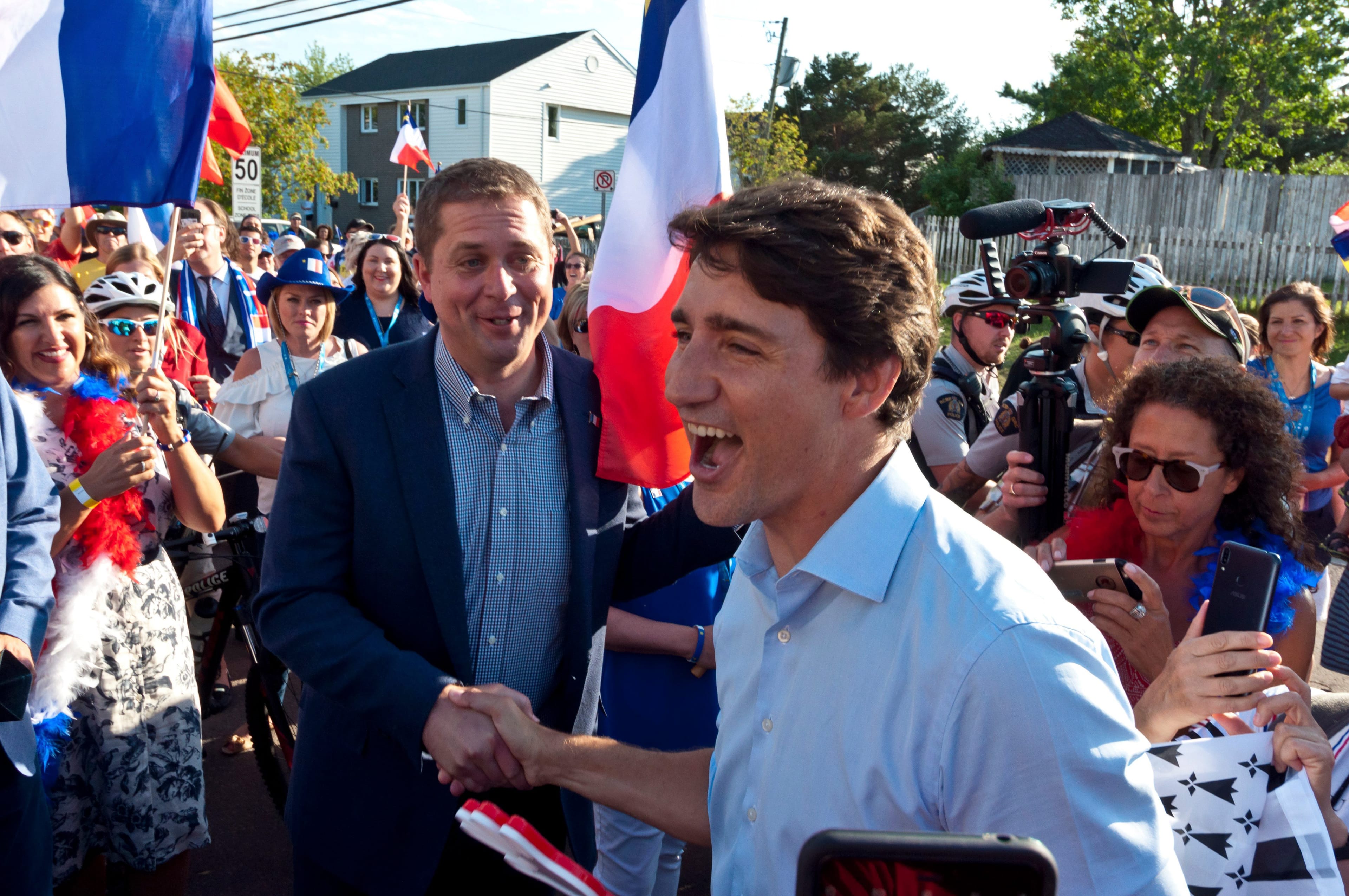 Prime Minister Justin Trudeau shakes hands with Conservative Leader Andrew Scheer during the celebration of the National Acadian Day and World Acadian Congress in Dieppe, N.B., on Aug. 15, 2019. (Marc Grandmaison/CP)