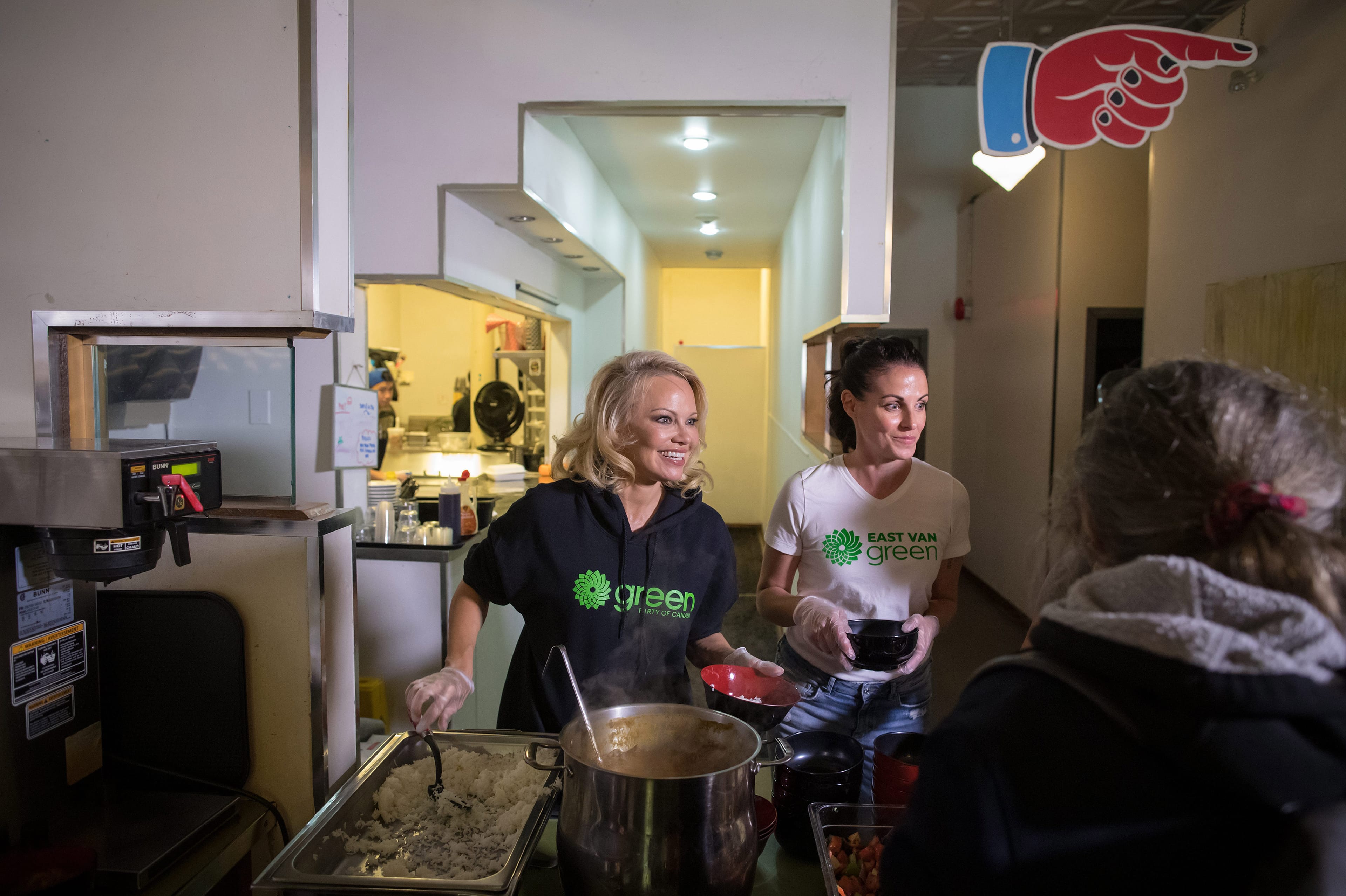 Actress and animal rights activist Pamela Anderson, left, and Bridget Burns, Green Party candidate for Vancouver East, serve free vegan meals to people at an event held to register voters for the election in the Downtown Eastside of Vancouver. (Darryl Dyck/CP)