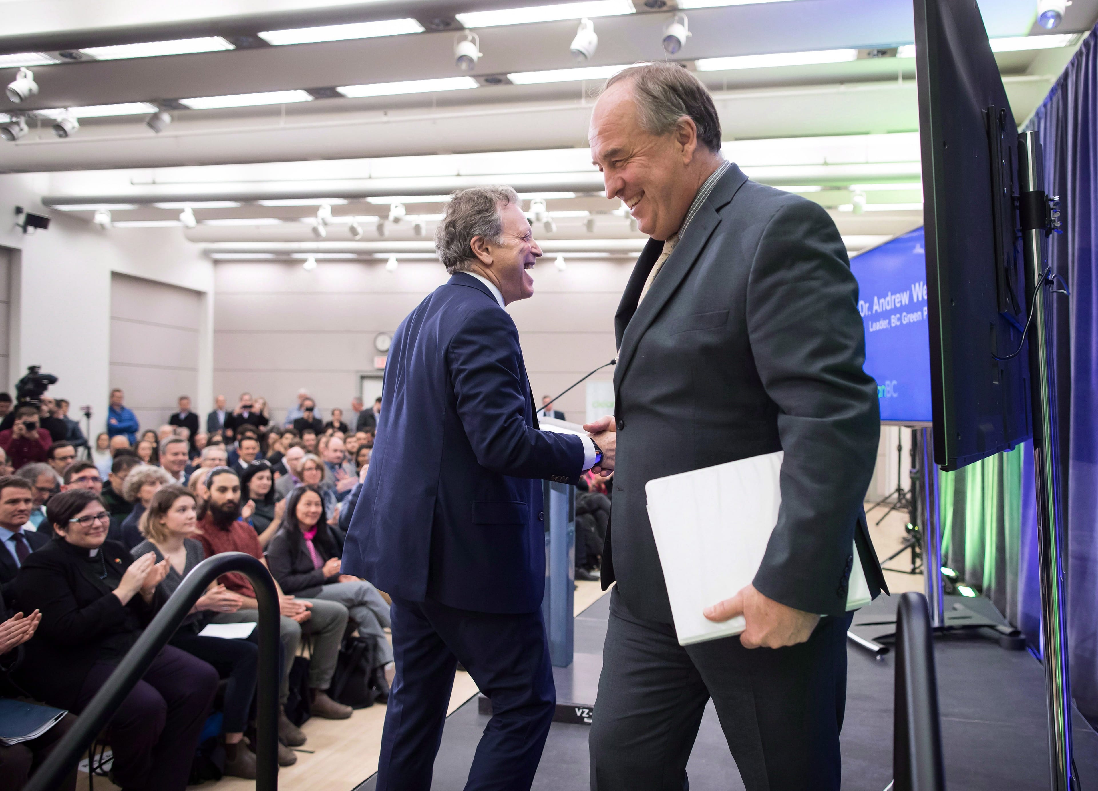 Weaver shakes hands with George Heyman, B.C.'s Minister of Environment and Climate Change Strategy at an appearance in December (Darryl Dyck/CP)