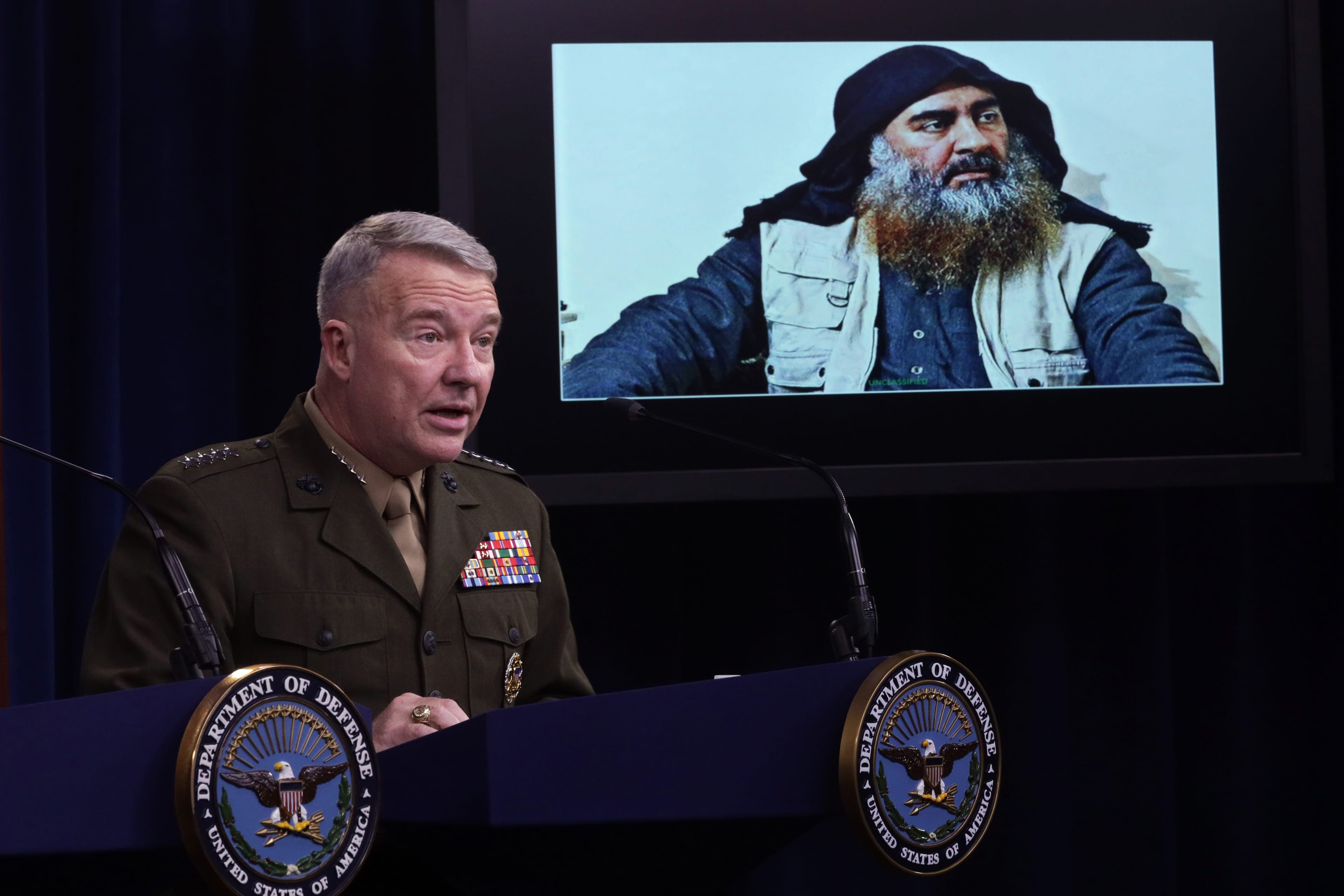 A U.S. Marine Corps general speaks as a picture of Baghdadi is seen during a press briefing on Oct. 30, 2019, at the Pentagon (Alex Wong/Getty Images)
