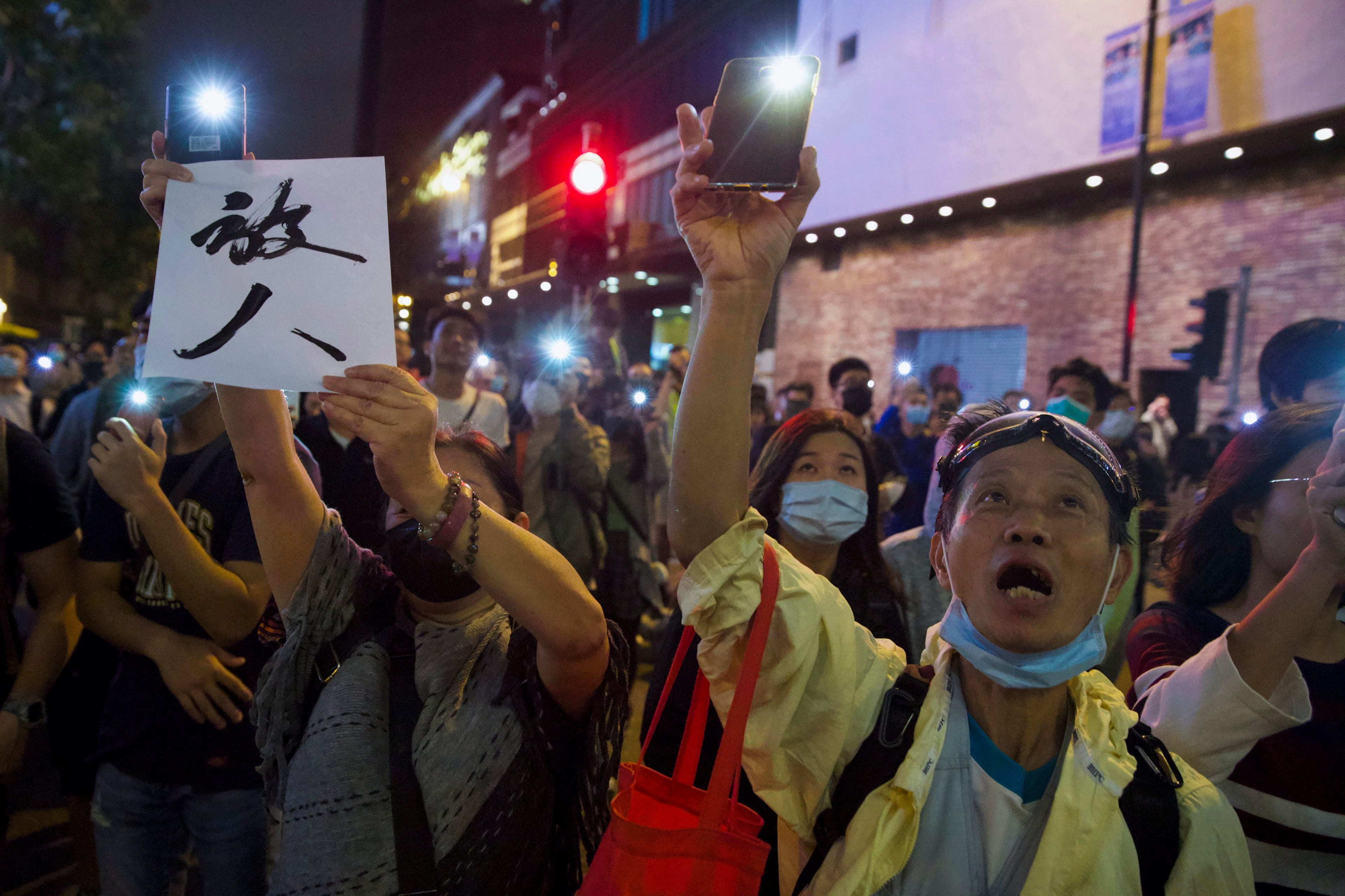 Protesters flash their smartphone lights om Monday near the Polytechnic University in Hong Kong to urge authorities to release the remaining trapped demonstrators (Ng Han Guan/AP)