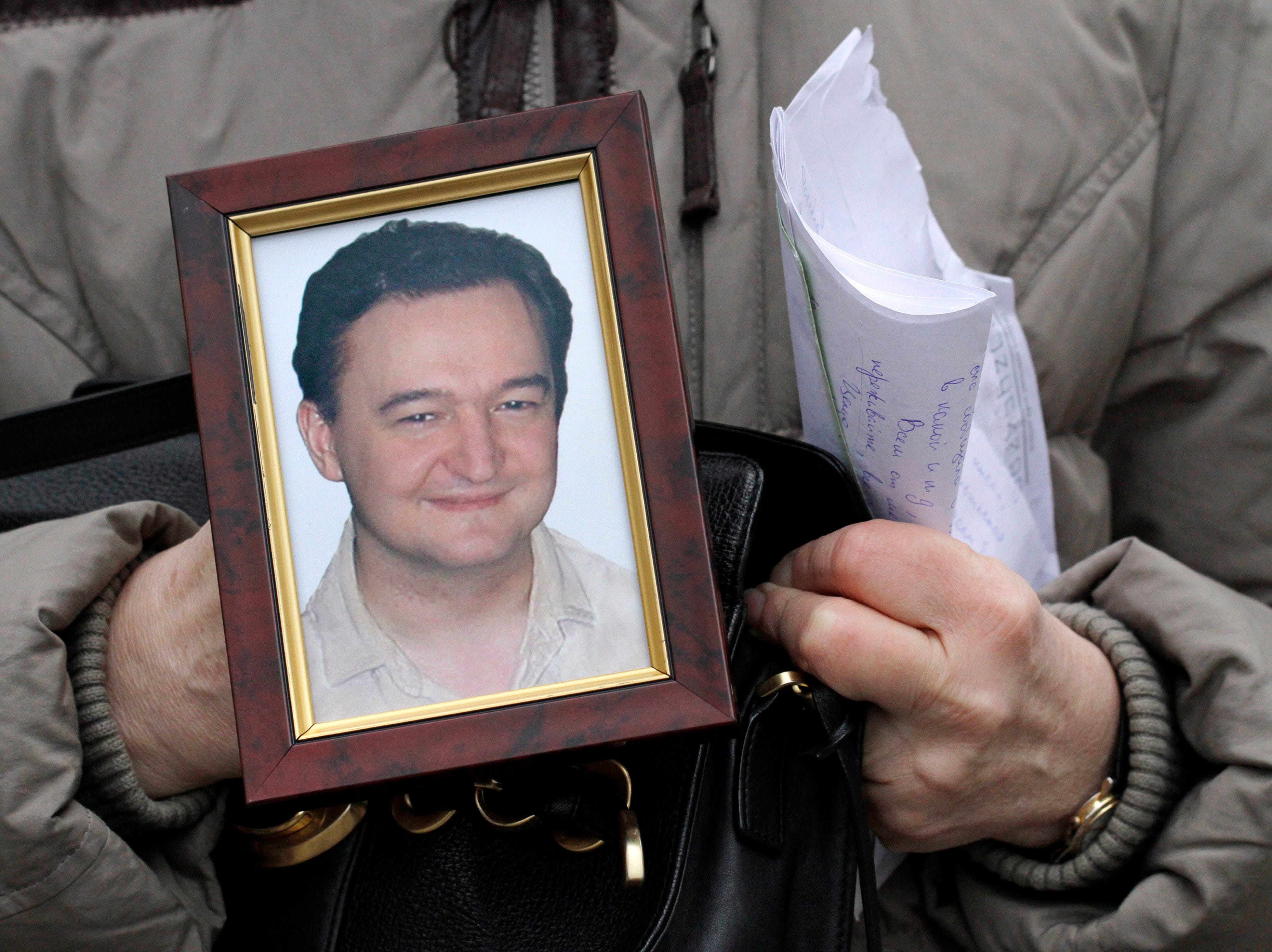 A portrait of Sergei Magnitsky is held up by his mother, Nataliya Magnitskaya, in November 2009 in Moscow (Alexander Zemlianichenko/ AP)