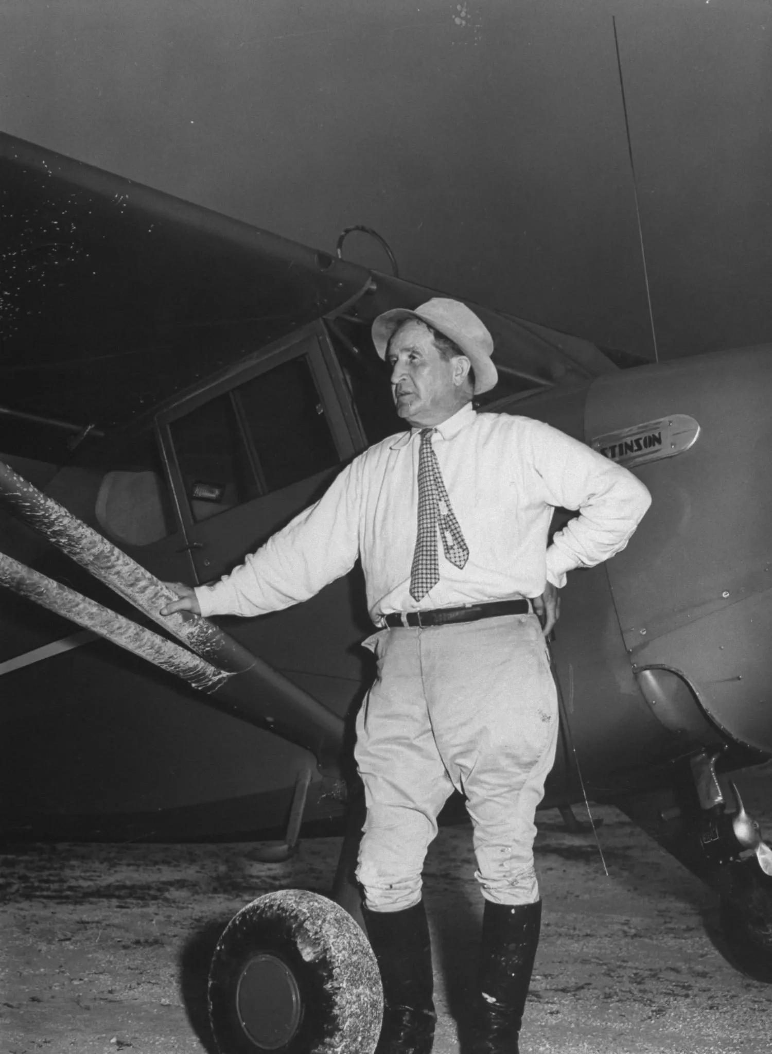 Sir Harry Oakes leaning against an airplane with his hand propped on his hip. (David E. Scherman/The LIFE Picture Collection/Getty Images)