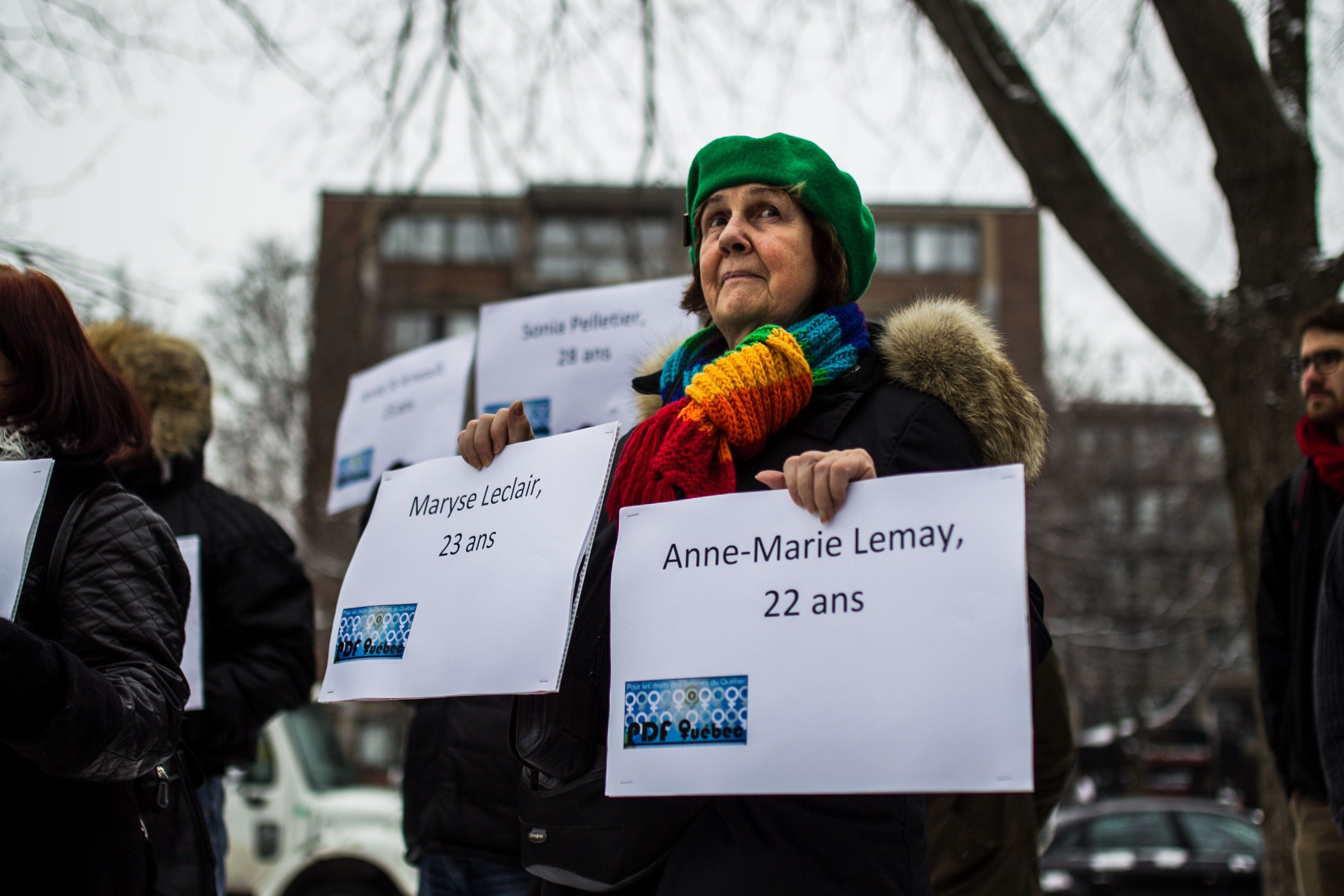 A woman holds papers that bears the victim's names as people take part in a ceremony at the memorial park to mark the 25th anniversary of the Ecole Polytechnique massacre in Montreal, Canada on December 6, 2014. (Photo by Amru Salahuddien/Anadolu Agency/Getty Images)