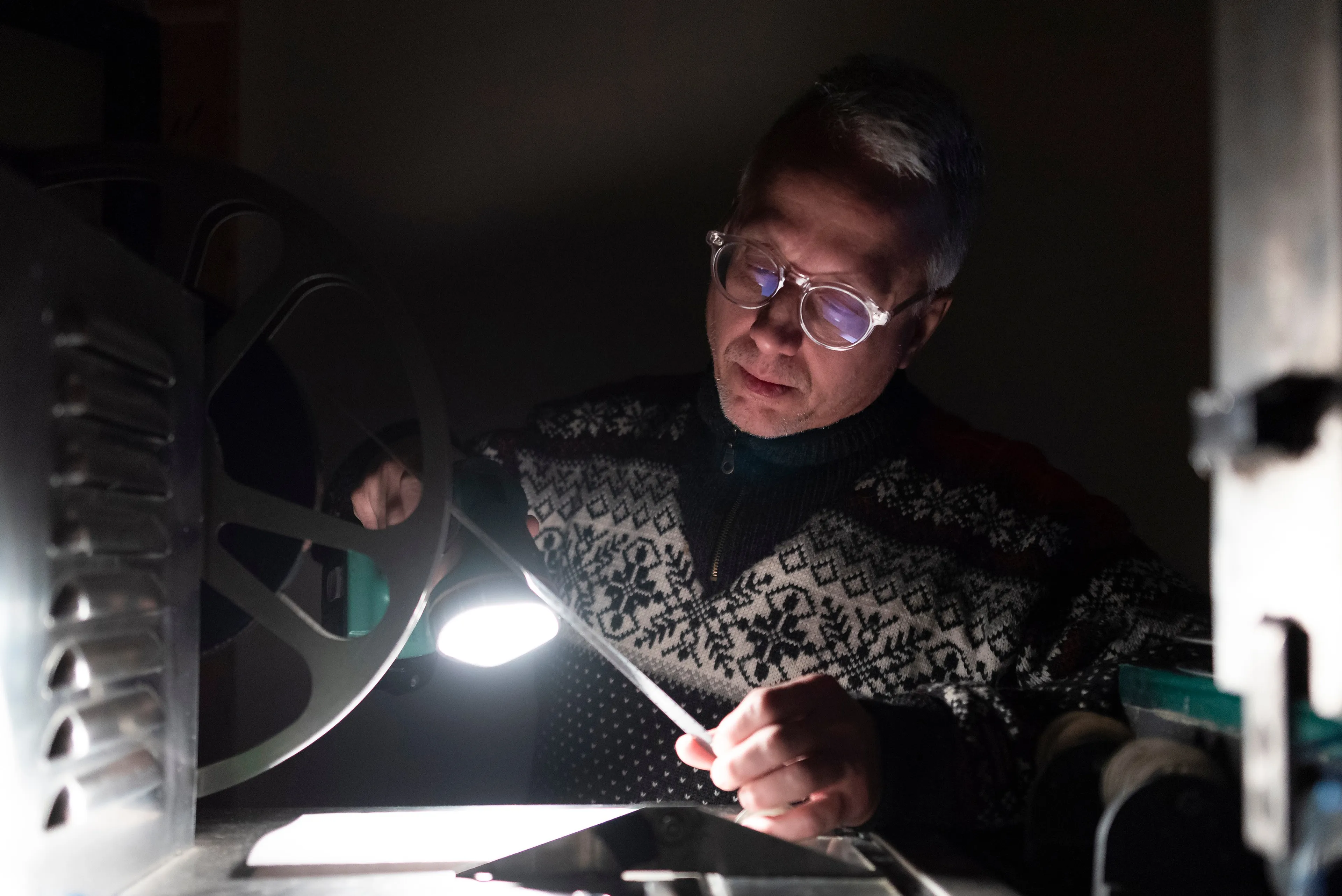 Greg Miller, owner of Film Rescue International, looks at a reel of film at the movie film processor at the company's office in Indian Head on Sunday December 22, 2019. (Photograph by Michael Bell)