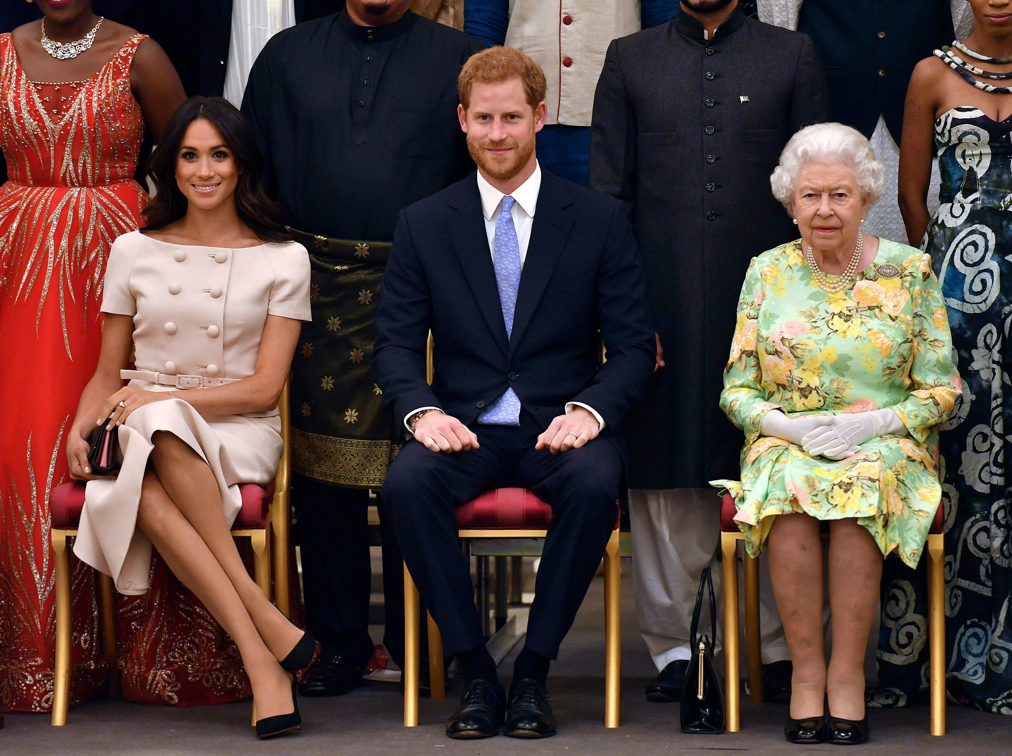 Britain's Queen Elizabeth, Prince Harry and Meghan, Duchess of Sussex pose for a group photo at the Queen's Young Leaders Awards Ceremony at Buckingham Palace in London on Jun. 26, 2018. (John Stillwell/AP Pool Photo/CP)