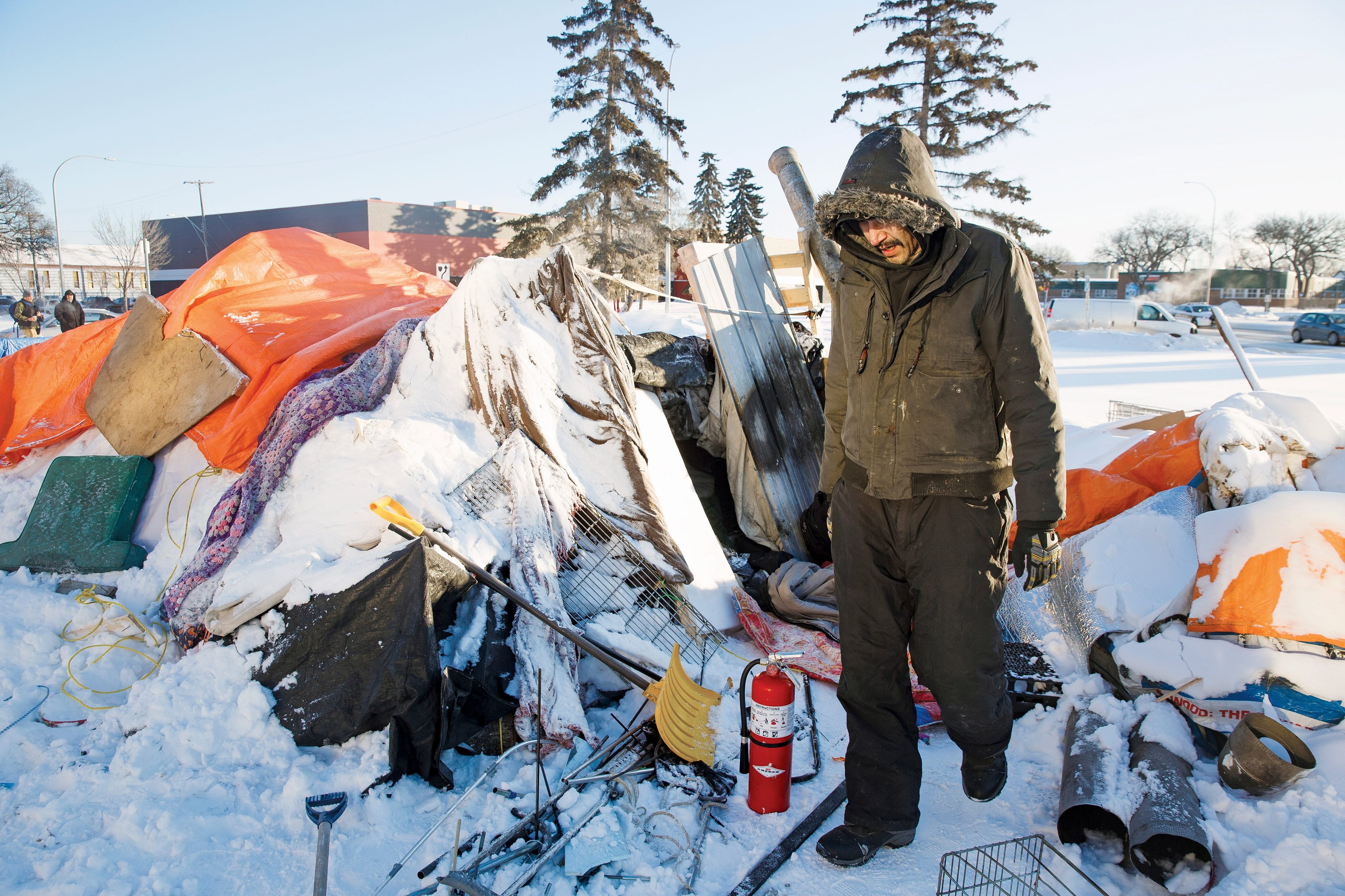 Tower pulls apart the home he has been living in for the last three months outside the MMF building alongside the Disraeli Freeway early Thursday morning, January 16, 2020. The people living in the camps have have been asked to move by the City of Winnipeg. (Mike Deal/Winnipeg Free Press)