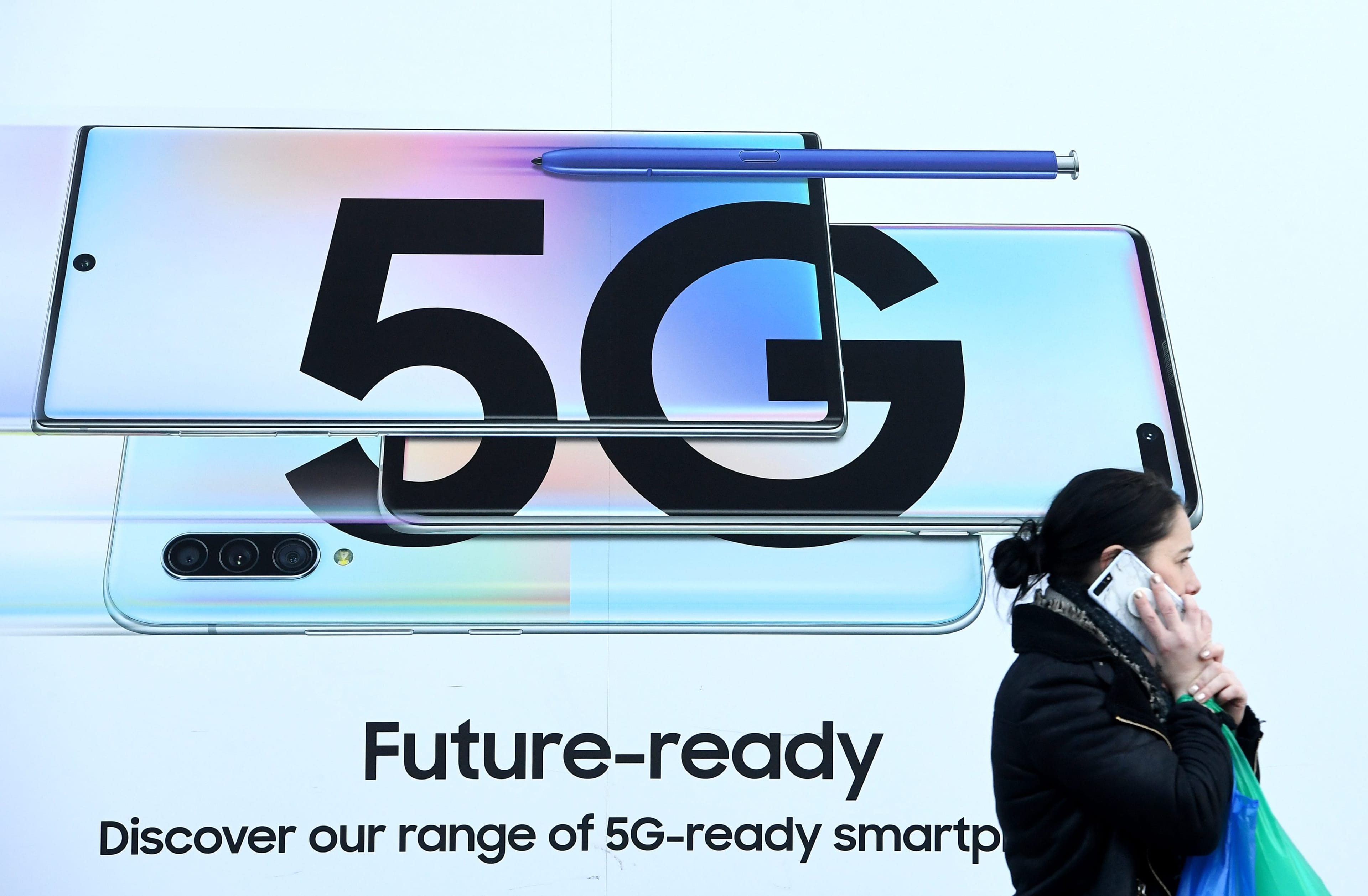 (A pedestrian walks past an advertisement displaying a 5G sign in London, Britain, on Jan. 29, 2020. The Government has decided to let the Chinese company Huawei to continue to be used in its 5G networks but with restrictions. (CP/EPA/FACUNDO ARRIZABALAGA)