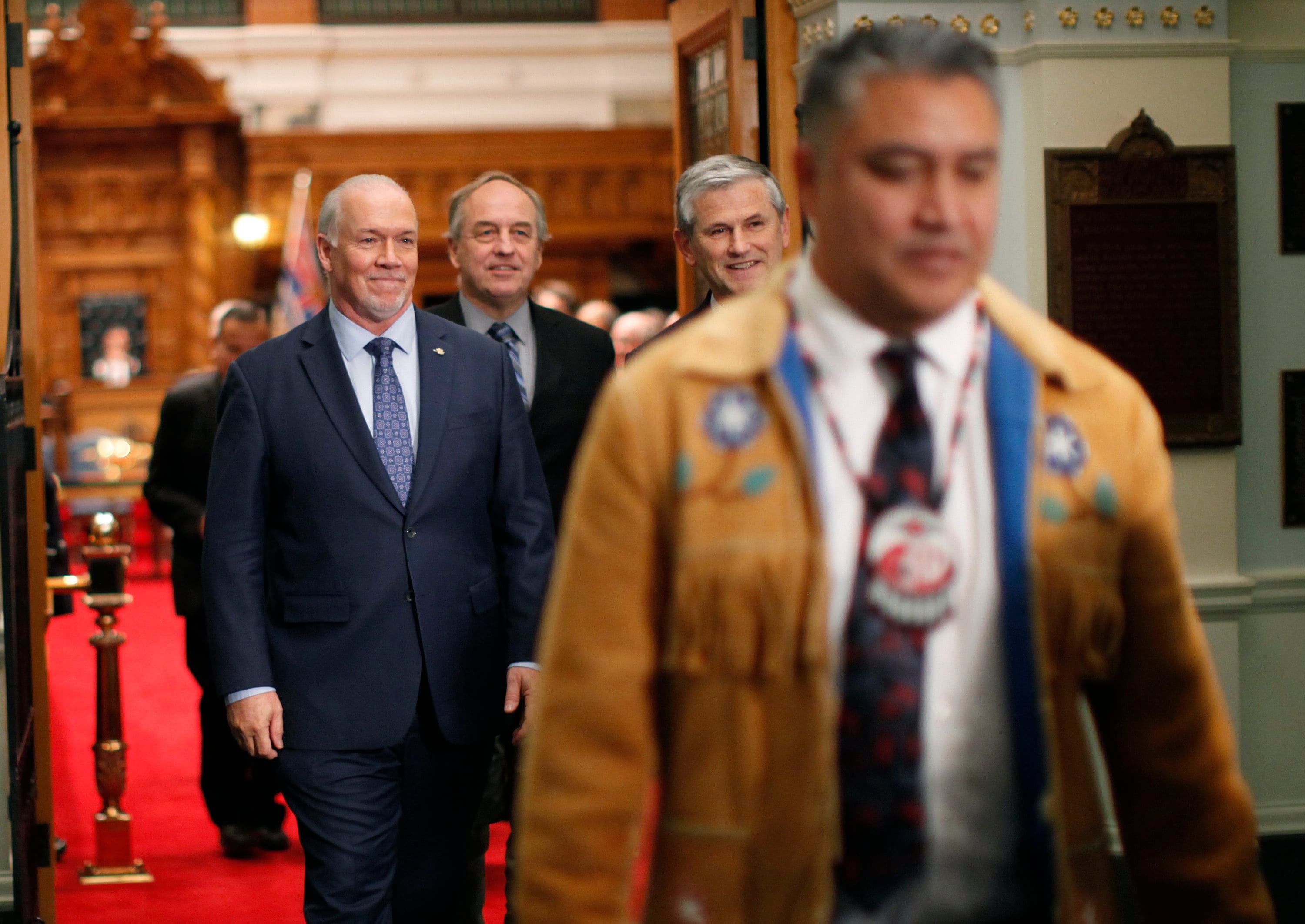 Regional Chief Terry Teegee leaves the legislative assembly joined by Premier John Horgan, B.C. Green Party leader Andrew Weaver and B.C. Liberal leader Andrew Wilkinson following an announcement about Indigenous human rights being recognized in B.C. with new legislation during a press conference at the provincial Legislature in Victoria, on Oct. 24, 2019. (Chad Hipolito/CP)