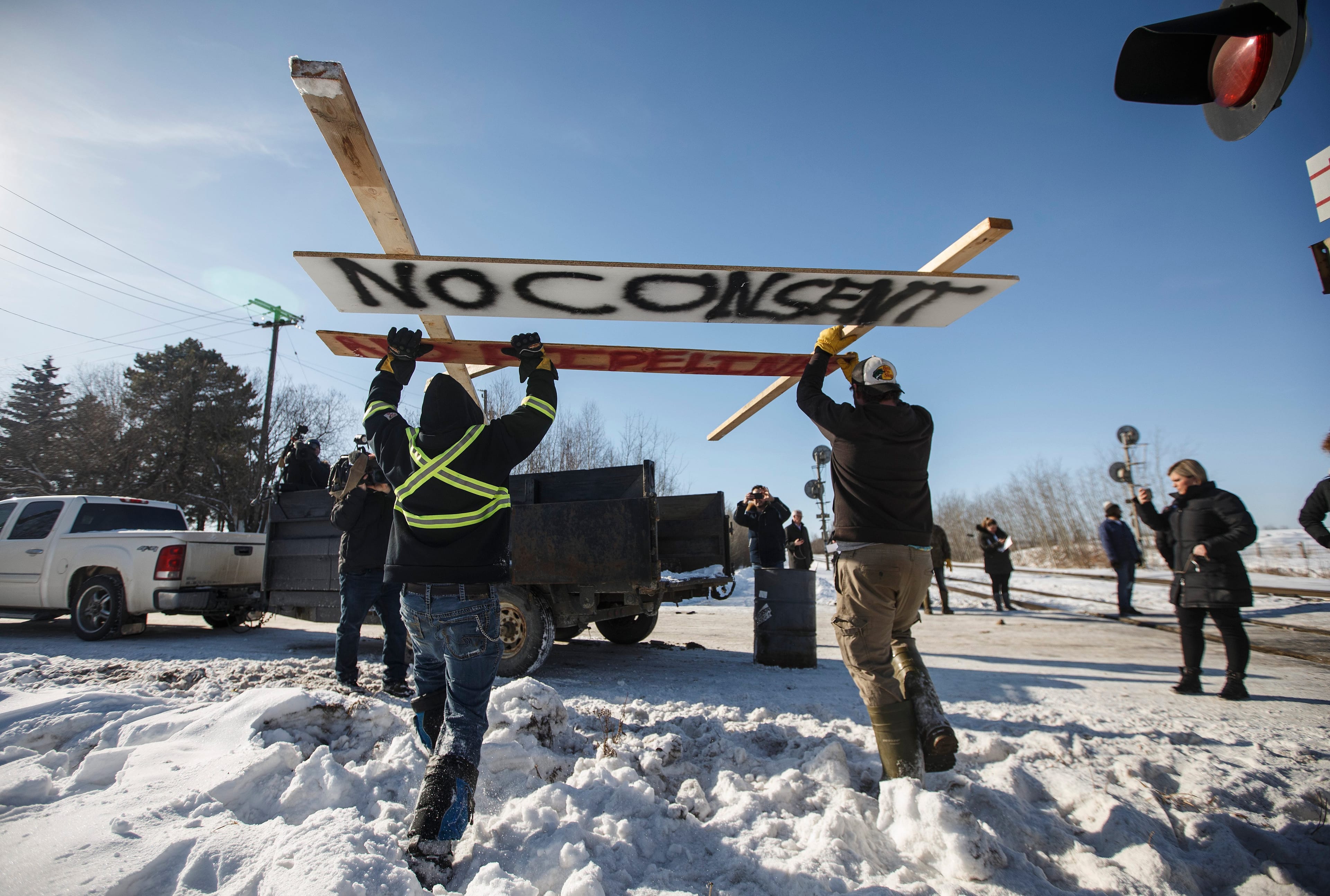 Counter protestors remove a piece of the blockade set up by supporters of the Wet'suwet'en hereditary chiefs at a CN Rail line just west of Edmonton on Wednesday, Feb. 19, 2020. (Jason Franson/CP)