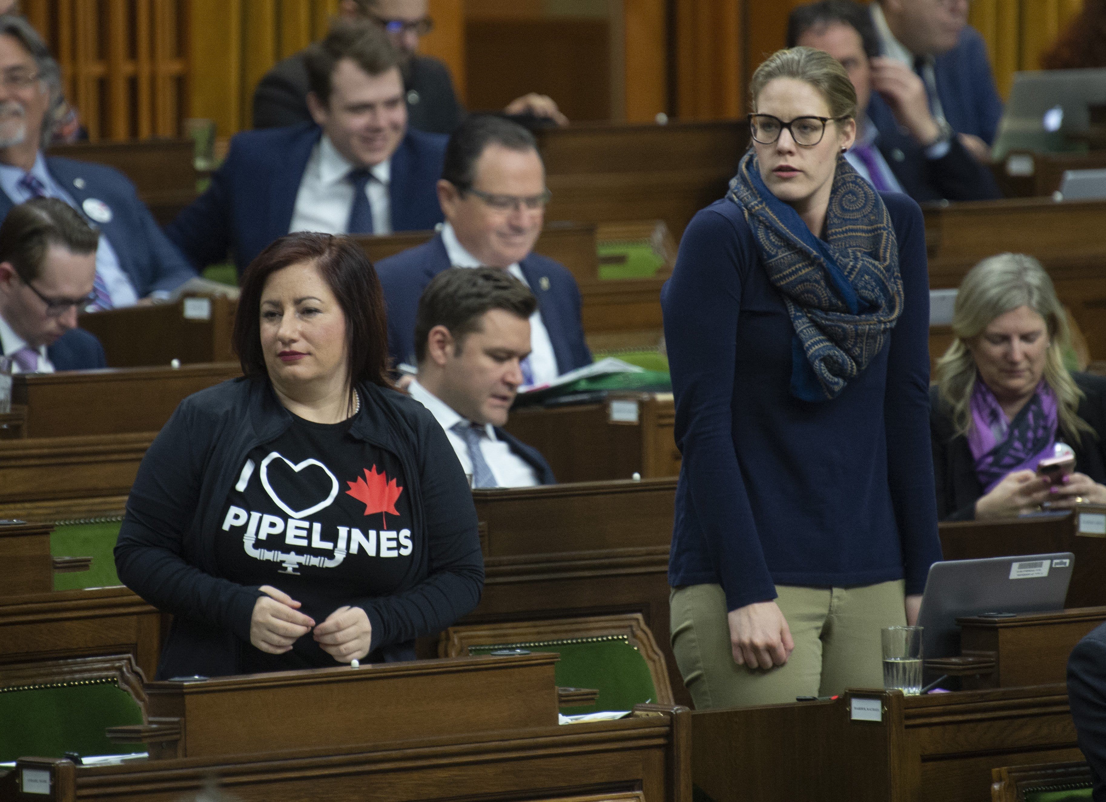 Conservative MPs Shannon Stubbs (left) and Rachel Harder rise to cast their vote during a marathon voting session in the House of Commons on March 21, 2019. (Adrian Wyld/CP)