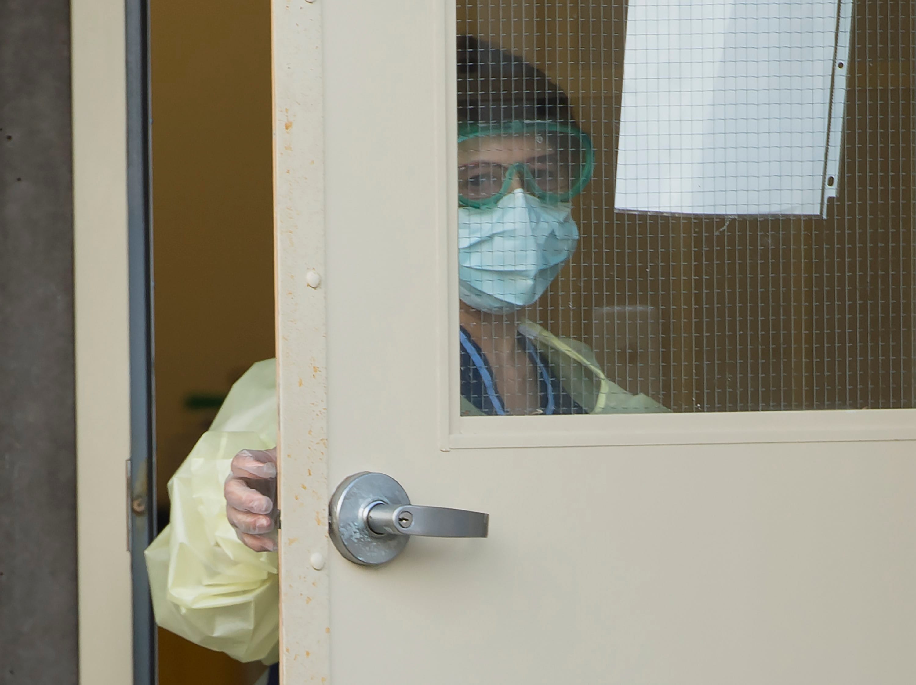 A worker donning personal protective equipment is seen outside the Lynn Valley Care Centre in North Vancouver, B.C. on Mar. 25, 2020. (Jonathan Hayward/CP)