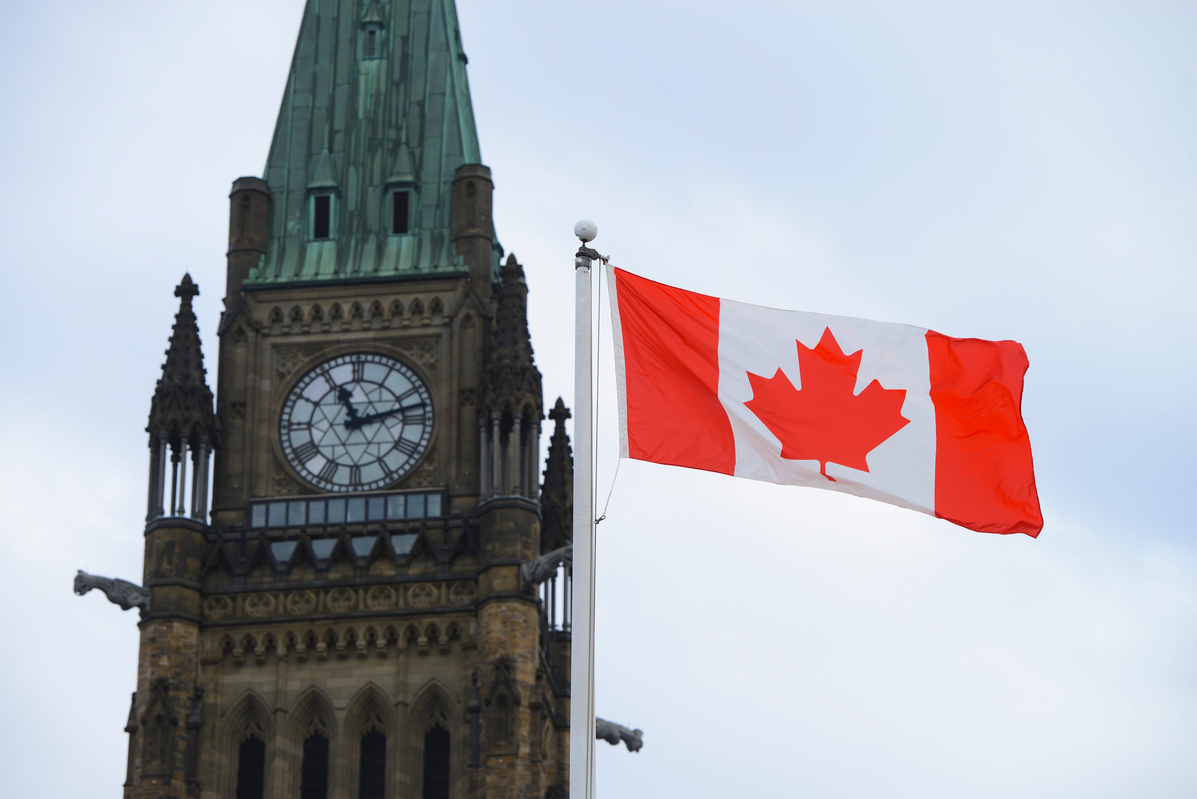 A Canadian flag flies by Parliament Hill in Ottawa on Mar. 13, 2020. (Sean Kilpatrick/CP)