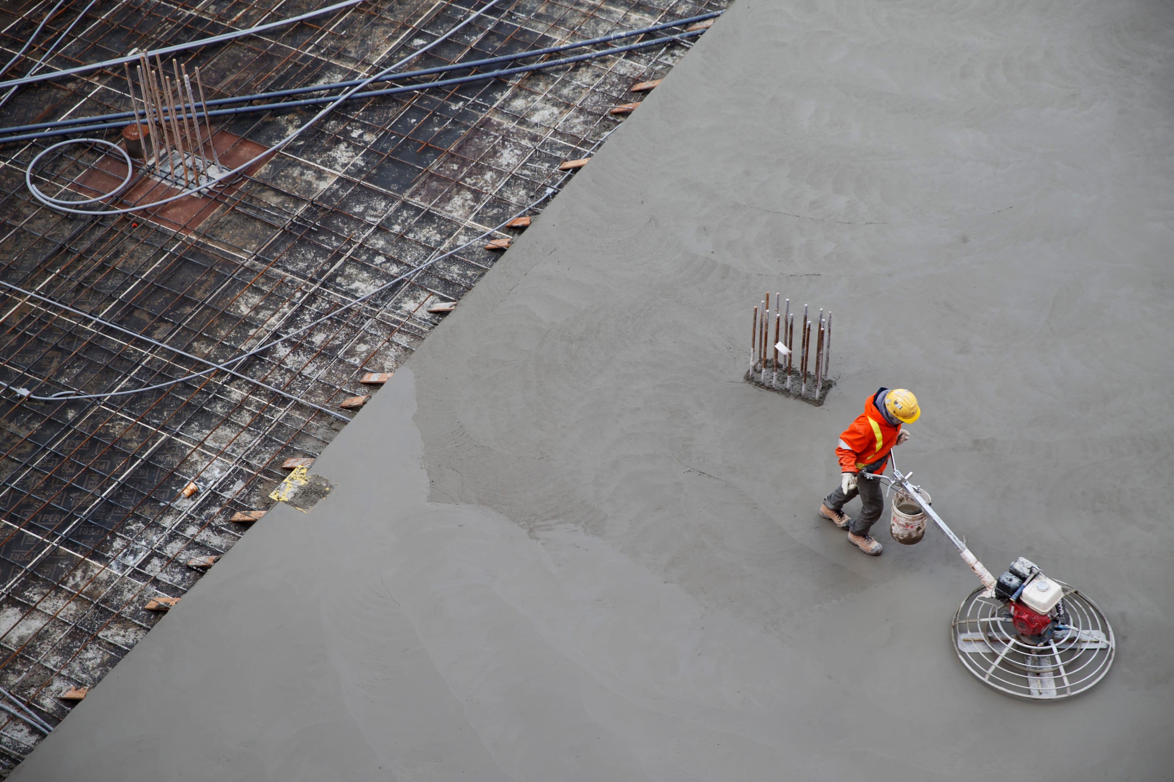 A worker is seen smoothing concrete at a development prior to a news conference at a construction site in Toronto on Jan. 16, 2020. (Cole Burston/CP)