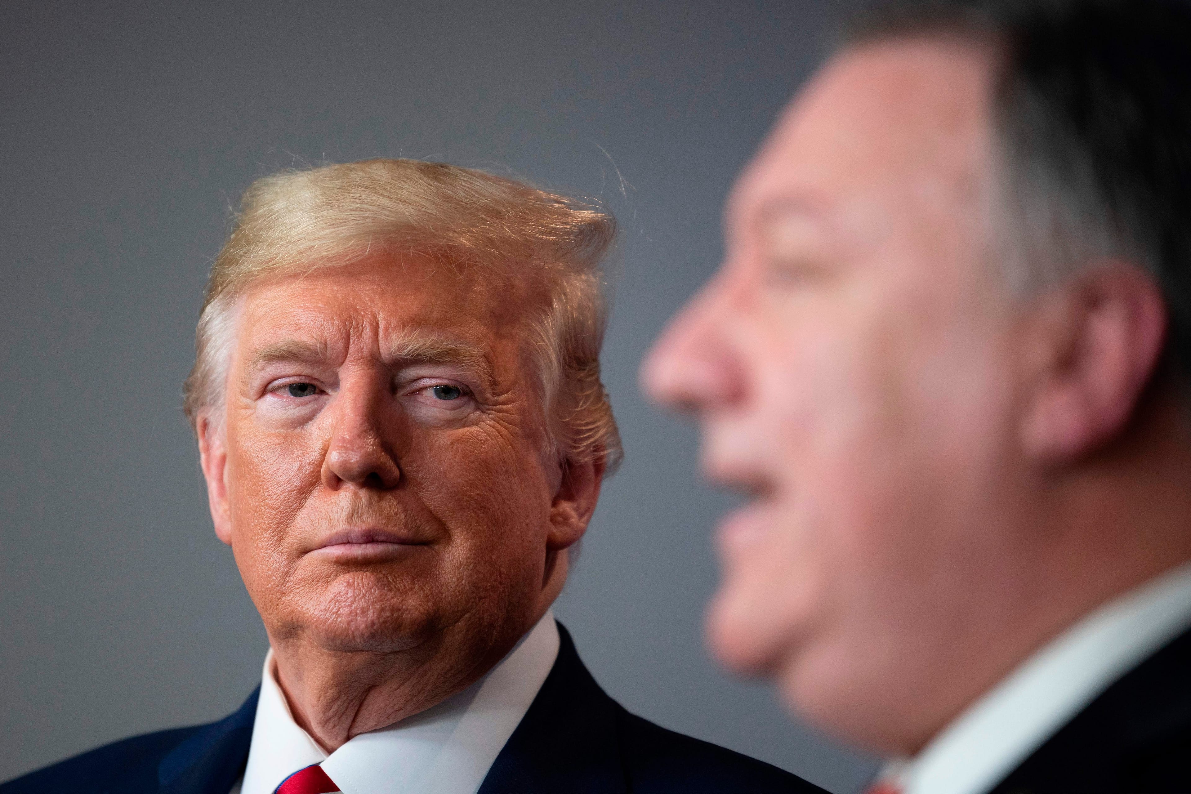 Trump listens as Secretary of State Mike Pompeo speaks during the daily briefing on COVID-19 at the White House on March 20, 2020 (JIM WATSON/AFP via Getty Images)