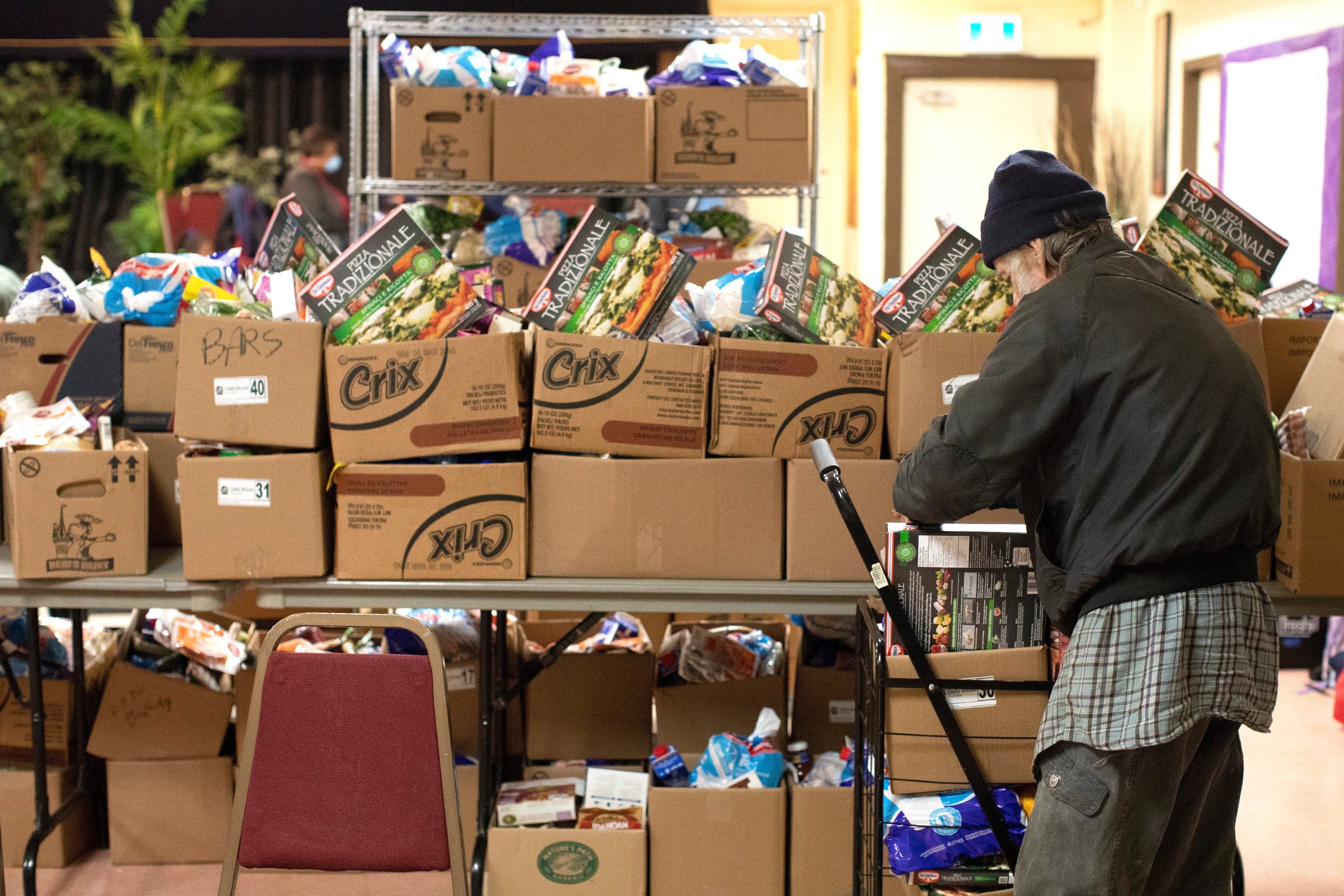 A recipient stacks his provisions in a cart at the Grant African Methodist Episcopal Church's Food Bank in Toronto on Friday March 20, 2020. THE CANADIAN PRESS/Chris Young