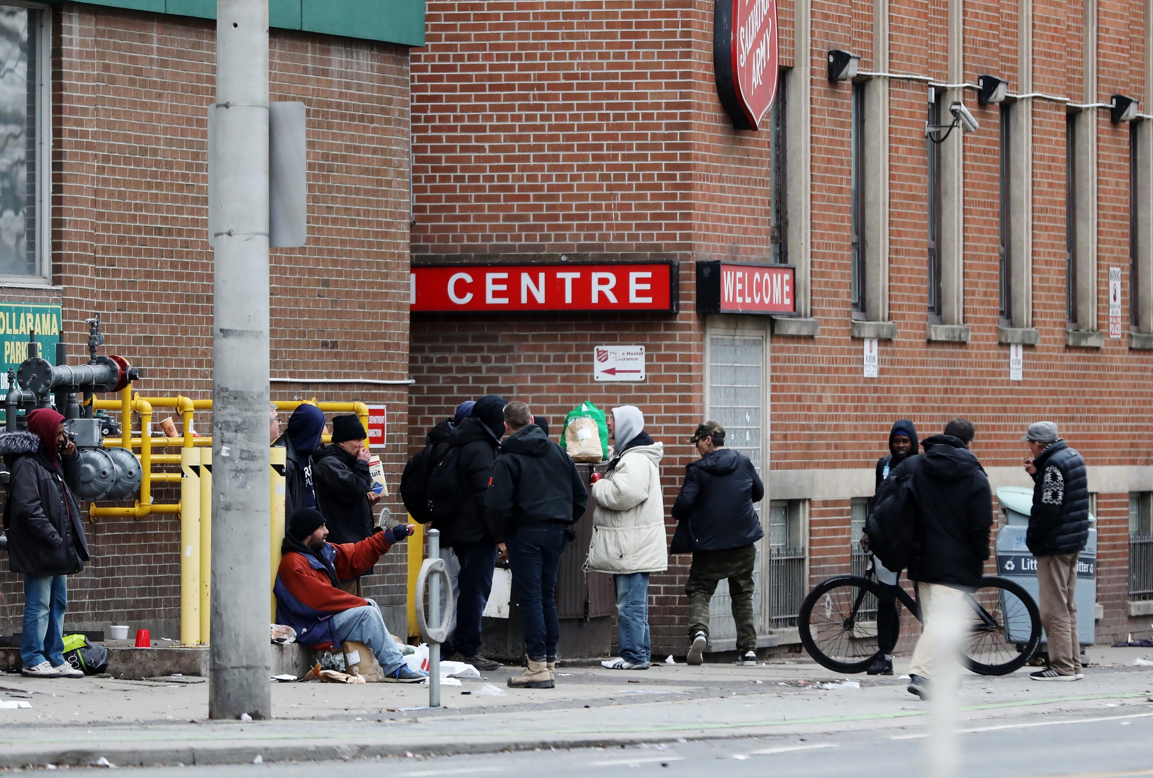 Men gather outside of a shelter in downtown Toronto on Saturday, March 28, 2020 (CP/Colin Perkel)