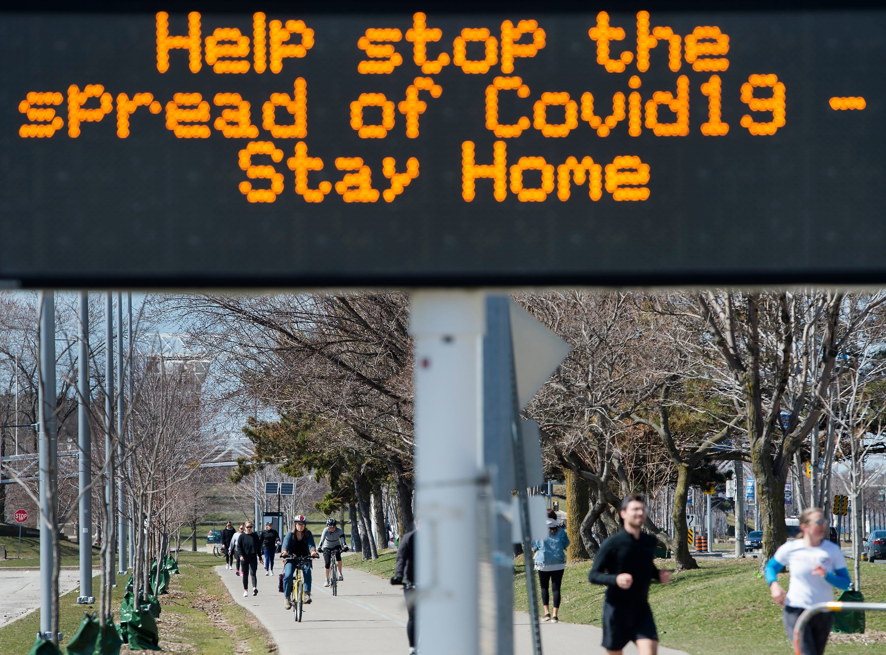 People exercise on the lake shore path along Lake Ontario in Toronto on April 2, 2020 (CP/Nathan Denette)