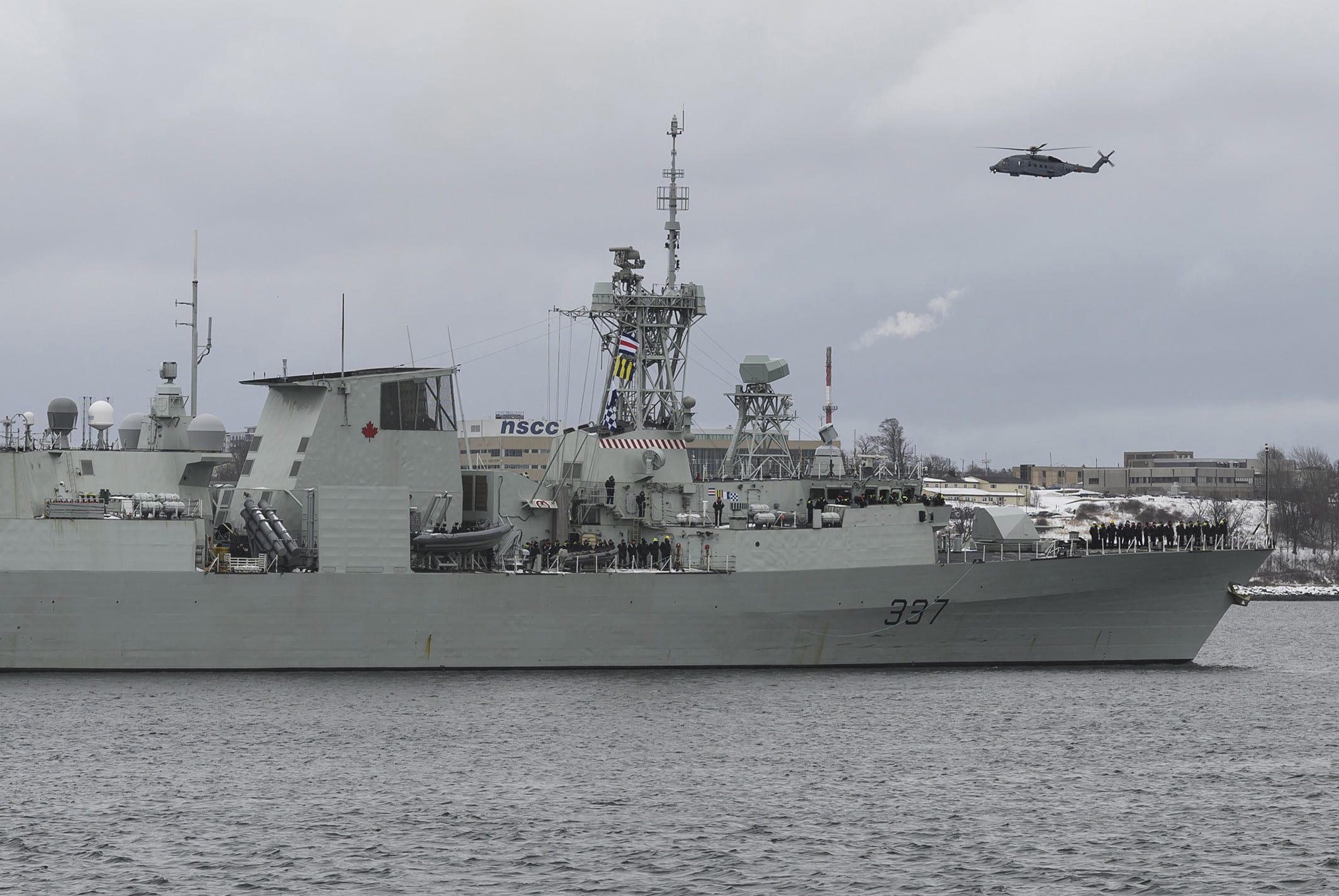 A Cyclone helicopter flies over HMCS Fredericton as its crew leaves the Halifax harbour for a six-month deployment as part of NATO's Operation Reassurance, on Jan. 20, 2020 (CP/Darren Calabrese)