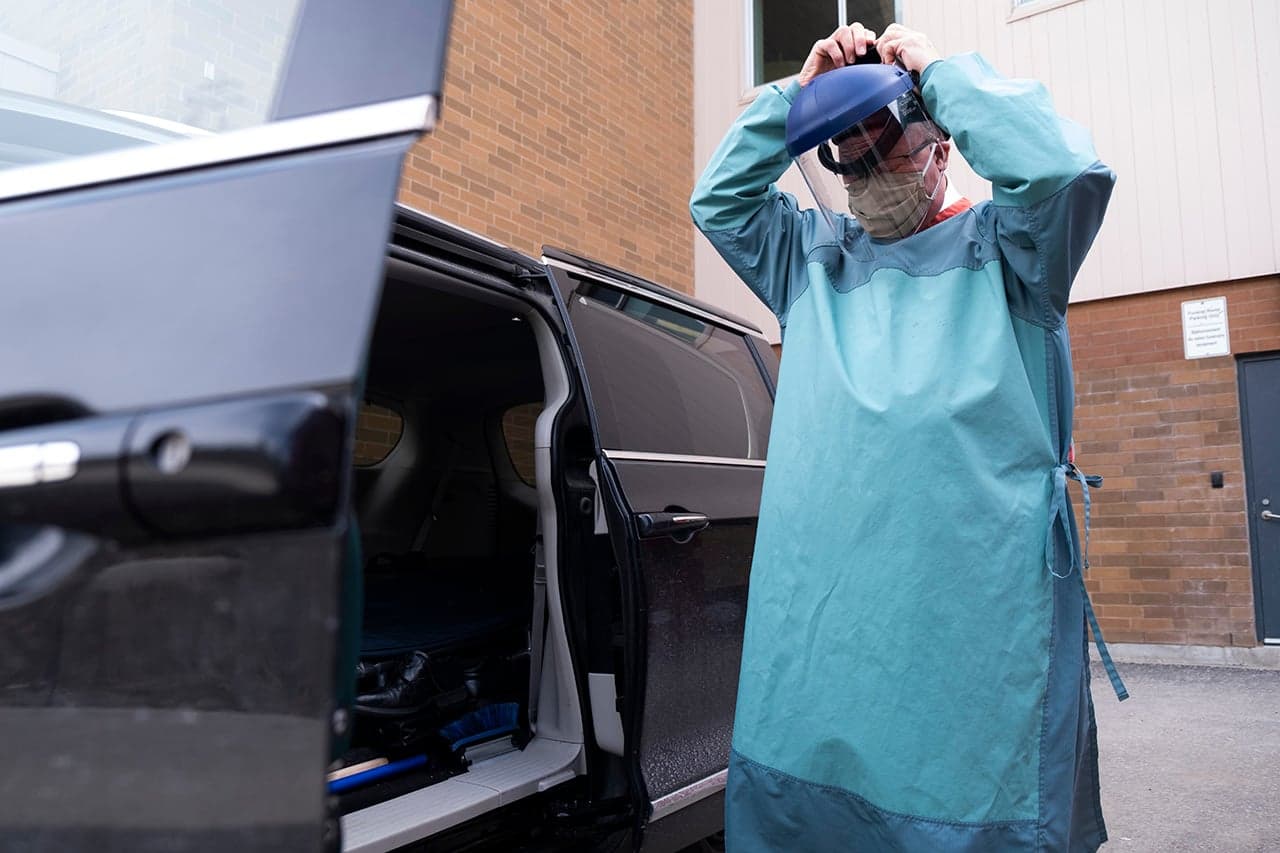 04/15/20 – Funeral Director Richard Paul puts on the required full PPE.