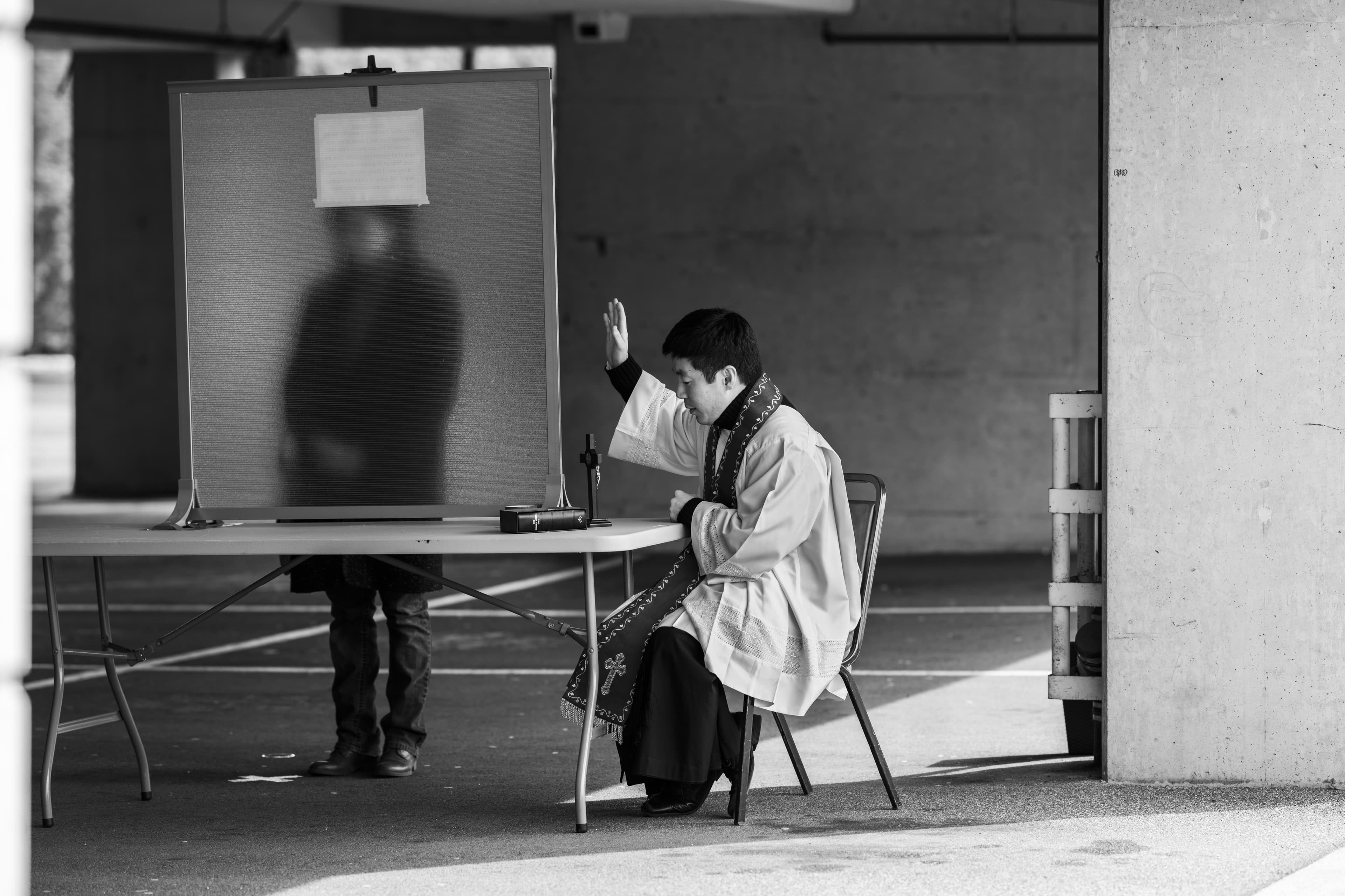 Rev. Felix takes a confession from the other side of the screen. (Jimmy Jeong)