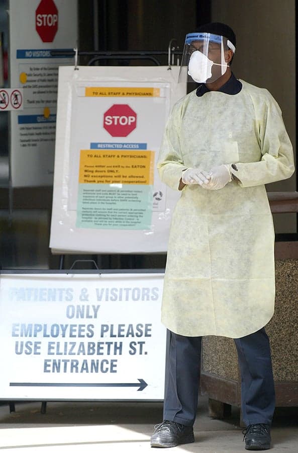 A hospital worker stands at the entrance of Toronto General Hospital wearing clothing to protect from Severe Acute Respiratory Syndrome, commonly known as SARS April 28, 2003 in Toronto, Ontario. There have been no new cases of SARS in Toronto outside the medical community for almost two weeks. (David Lucas/Getty Images)