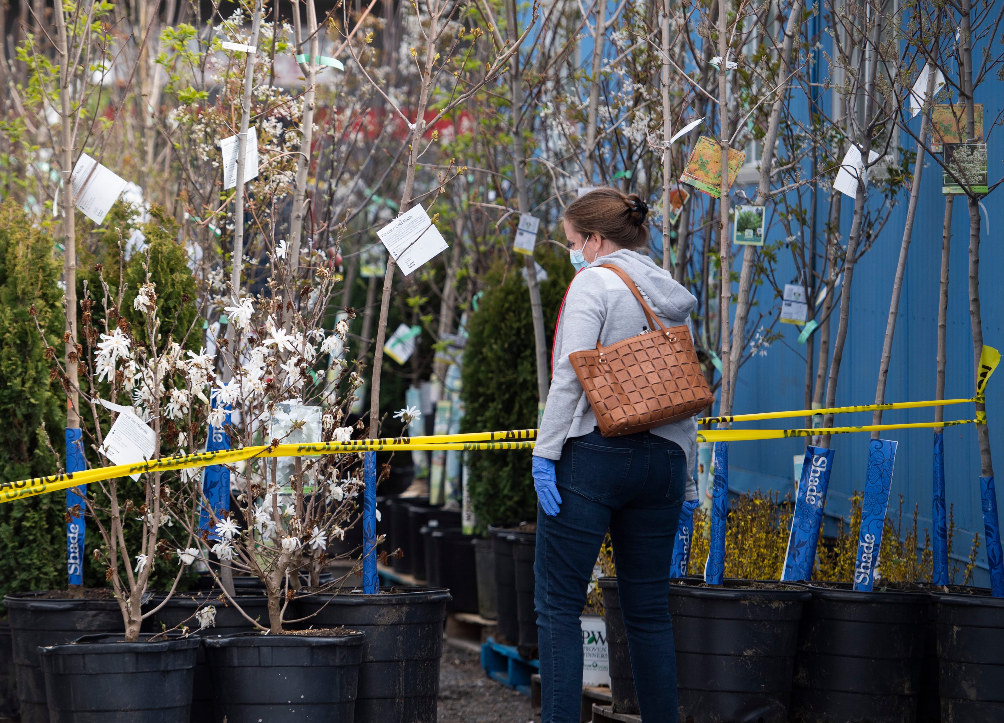 A customer looks at plants at a garden centre in the Ottawa community of Stittsville, on May 2, 2020 (CP/Justin Tang)
